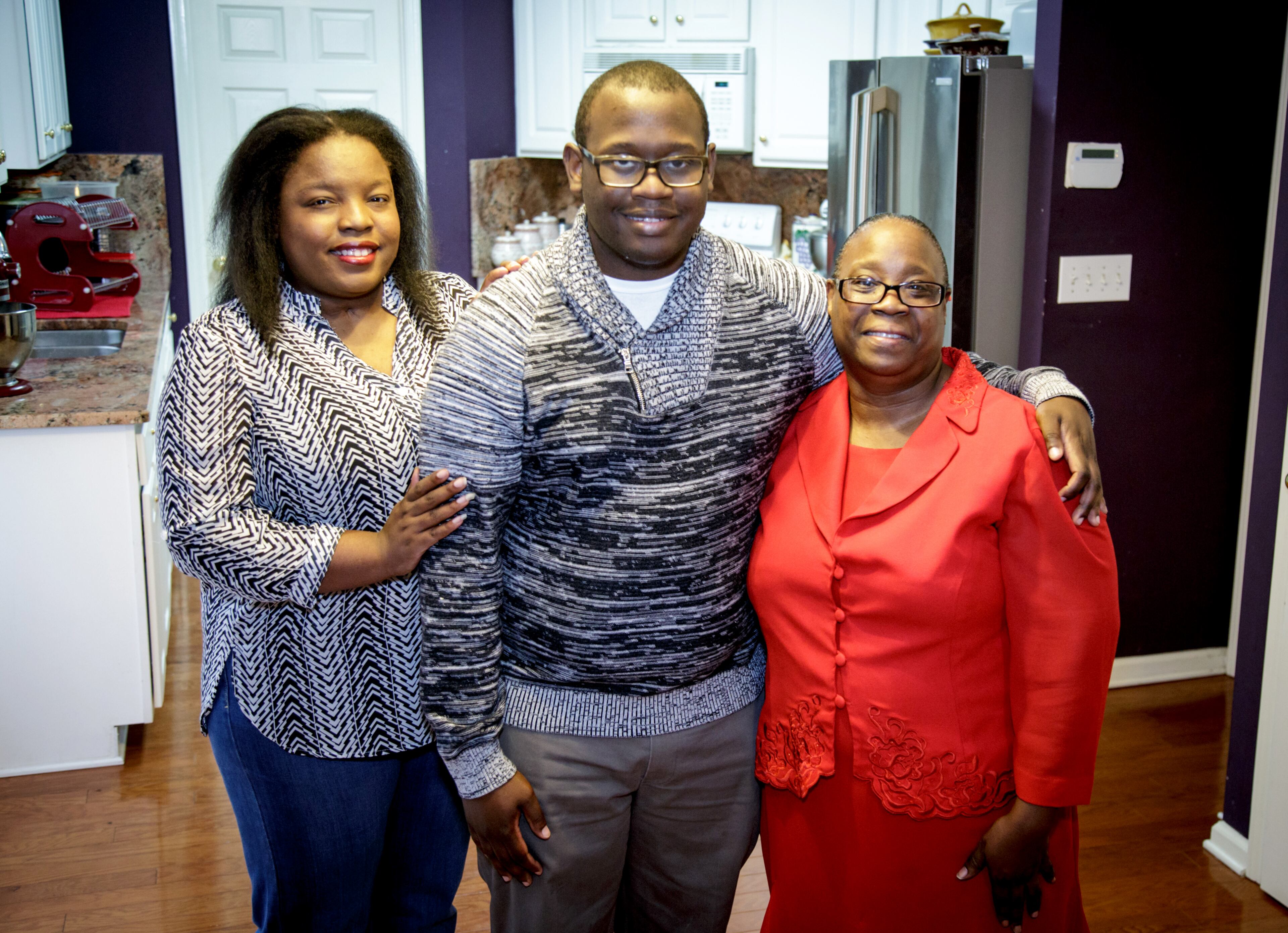 Duane Carver stands with this sister Chriscynthia Young (L) and his mother Sosa Carter (R) in their Stockbridge, GA home Wednesday, December 14, 2016. All three who at one time lived in poverty, now have college degrees and live together in Stockbridge. STEVE SCHAEFER / SPECIAL TO THE AJC