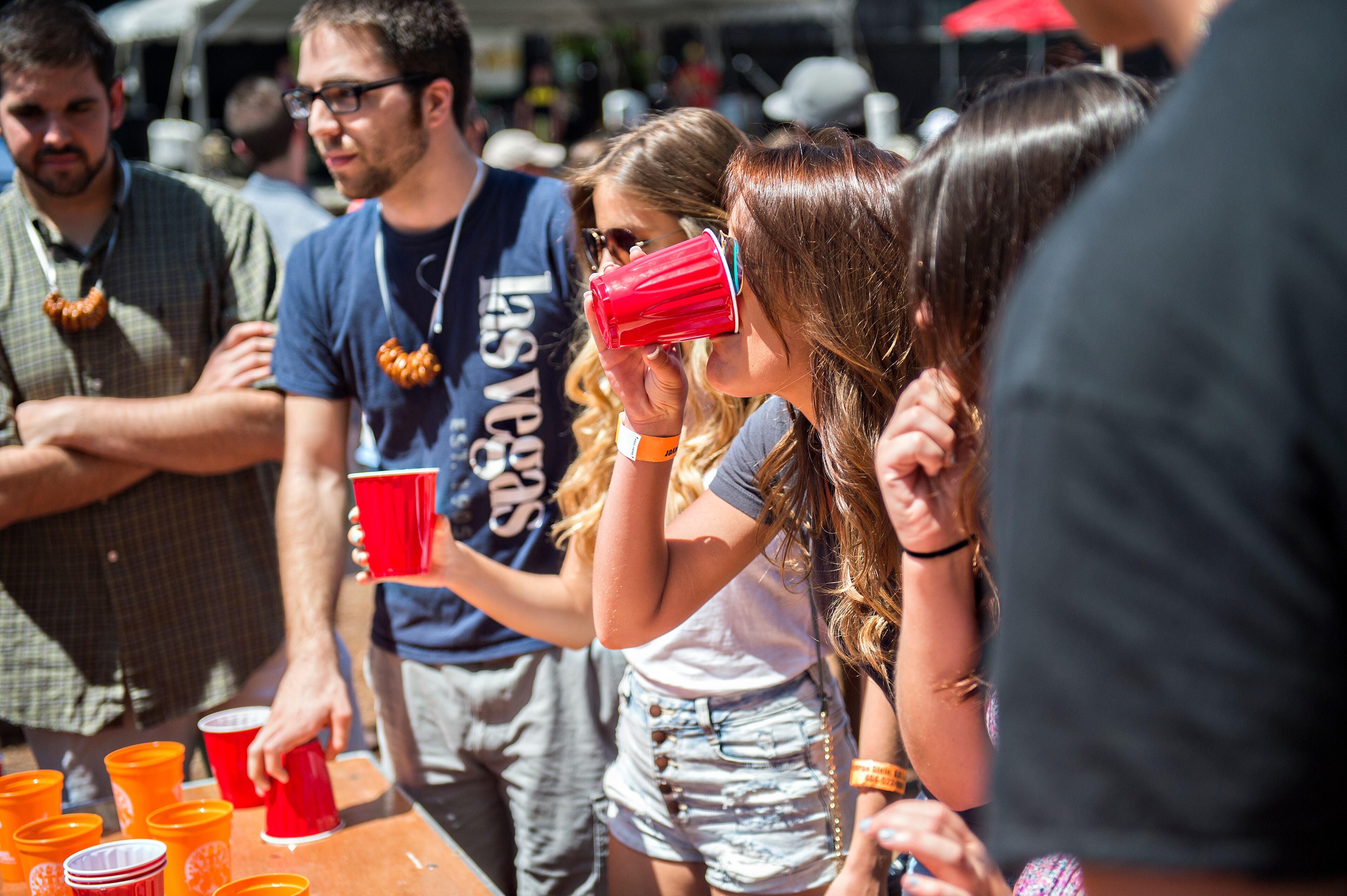 Jordyn Moerner (right) takes a drink while playing flip cup during the Hogs & Hops Festival at The Masquerade in Atlanta on Saturday, April 11, 2015. The annual festival featured beer and barbeque as well as live music and games. JONATHAN PHILLIPS / SPECIAL