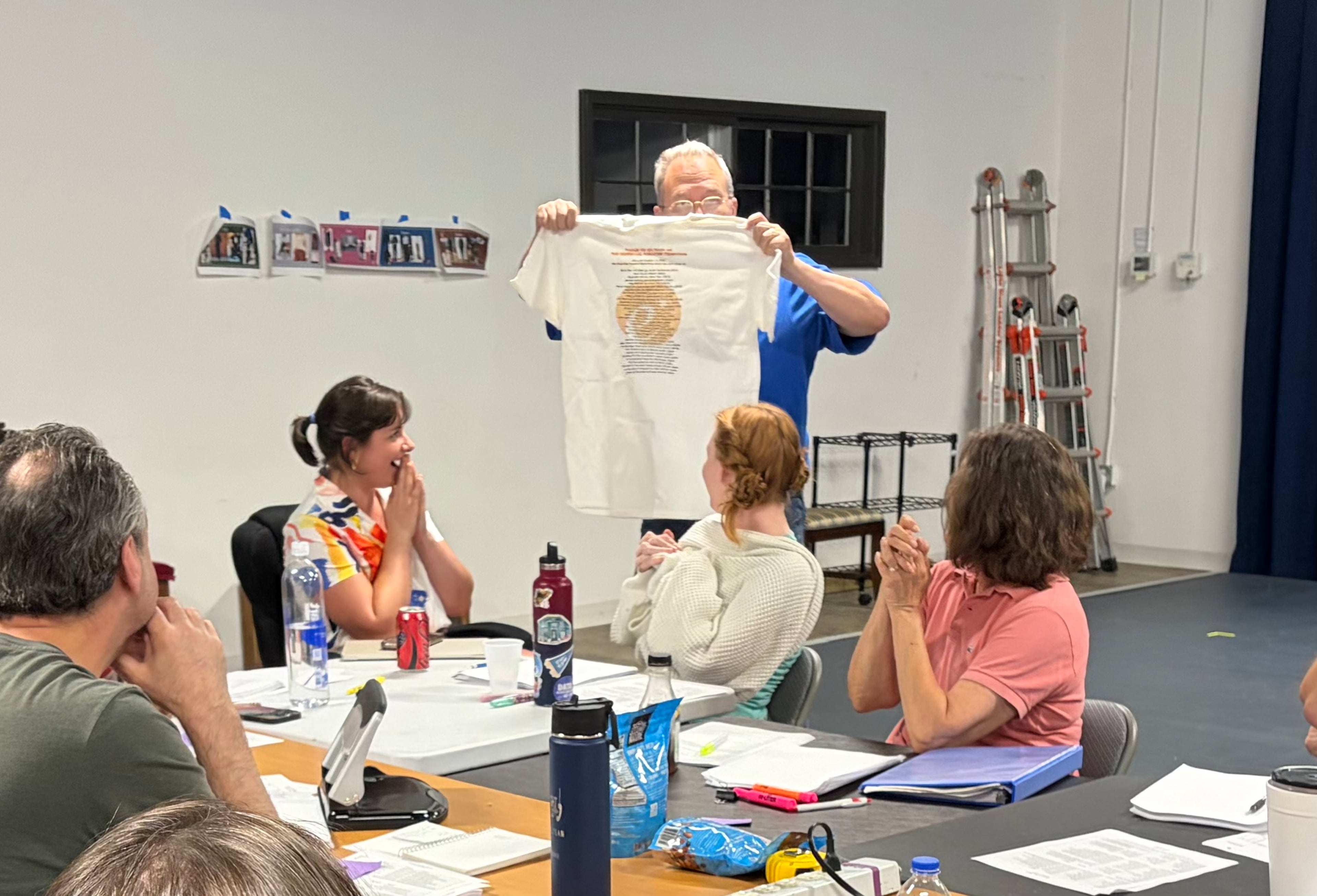 Essential Theatre Artistic Director Peter Hardy presents 2026 Essential Theatre Playwriting Award winner Susan Swavely with an "Essential Tradition" commemorative T-shirt. (Courtesy of Essential Theatre)