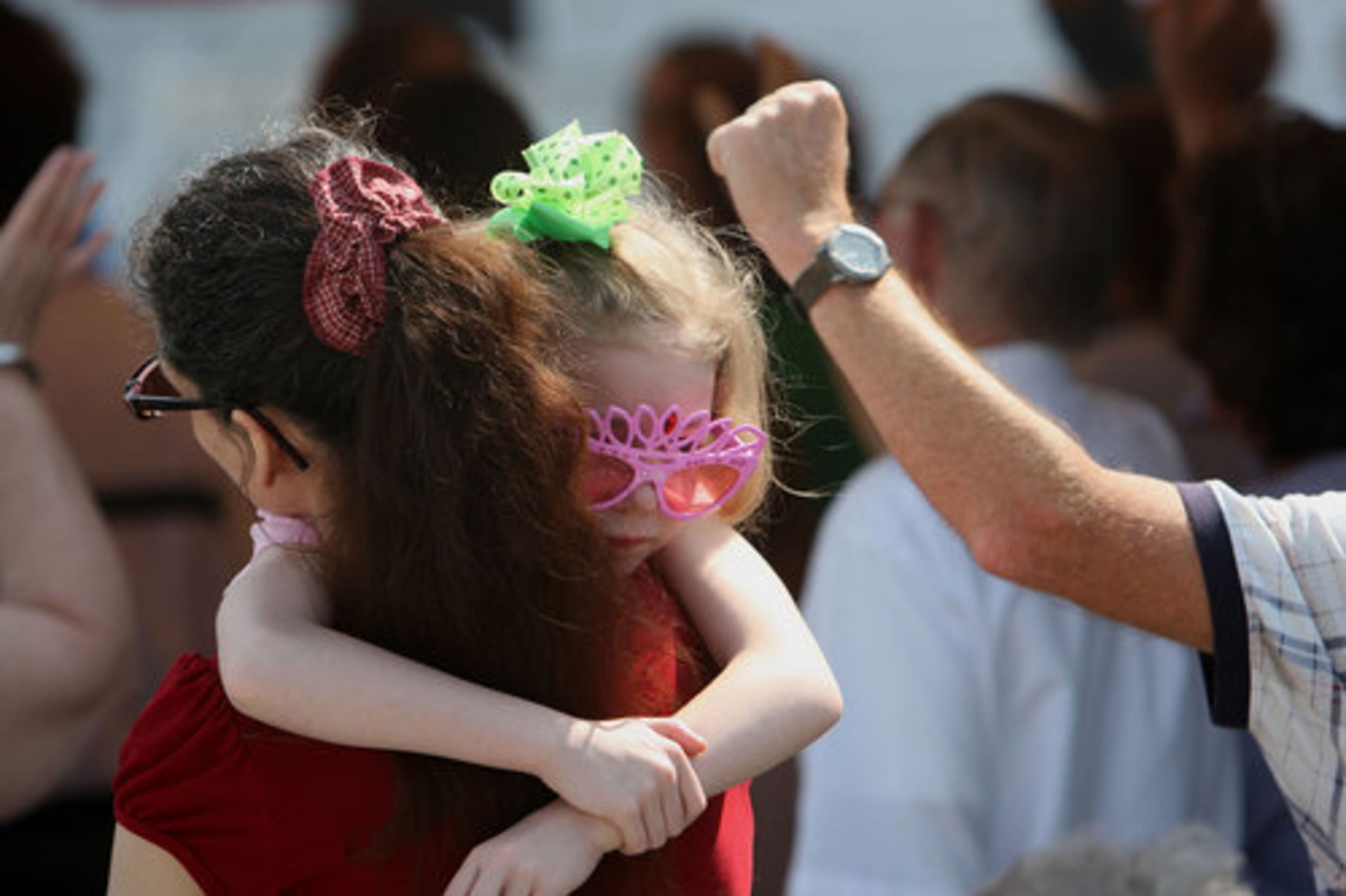 Macey Woodall, 7, clings to her mother Shannon Woodall during Sunday worship service under a makeshift tent of the parking lot of the Crowe Springs Baptist Church in Cartersville, May 1, 2011. "We lived down the street and sustained some damaged," Shannon said.