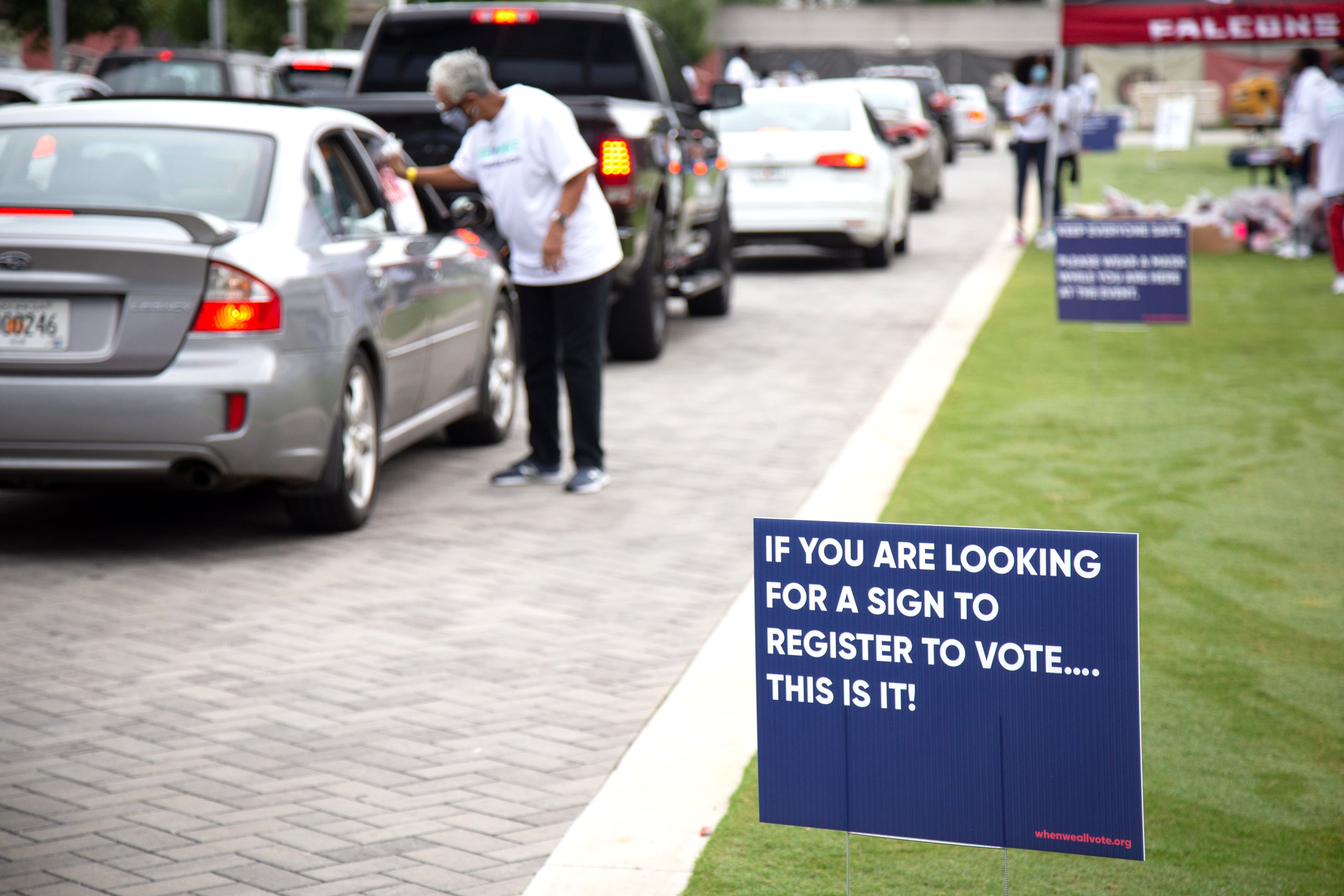 Voter registration signs line the route at the Fuel the Vote food giveaway and voter registration drive at The Home Depot Backyard in Atlanta on Saturday, September 26, 2020. Sponsored by Michelle Obama's nonprofit organization When We All Vote , the event provided food and groceries to an estimated 2,500 attendees and helped them prepare to cast their ballots in November. STEVE SCHAEFER / SPECIAL TO THE AJC