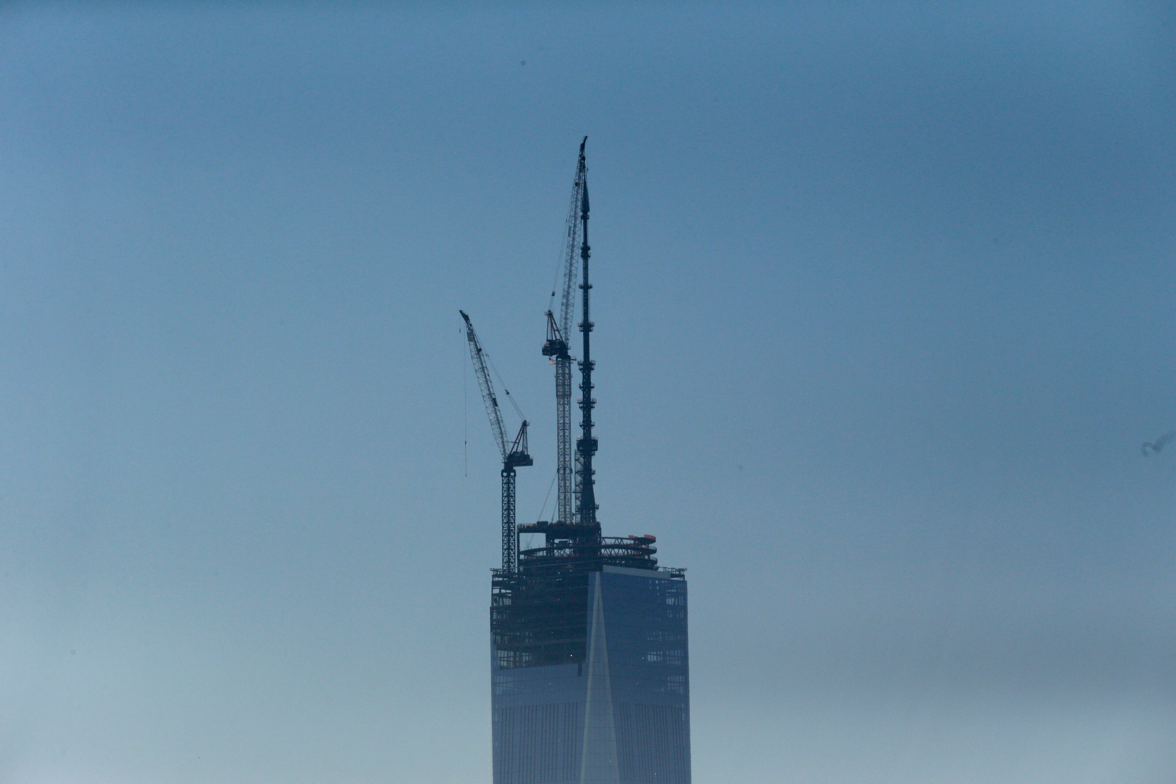 A 408-foot spire is set into place at the top of One World Trade Center seen from the Heights neighborhood of Jersey City, N.J., Friday, May 10, 2013. With the spire, the building rises at a symbolic 1,776 feet tall. (AP Photo/Julio Cortez)