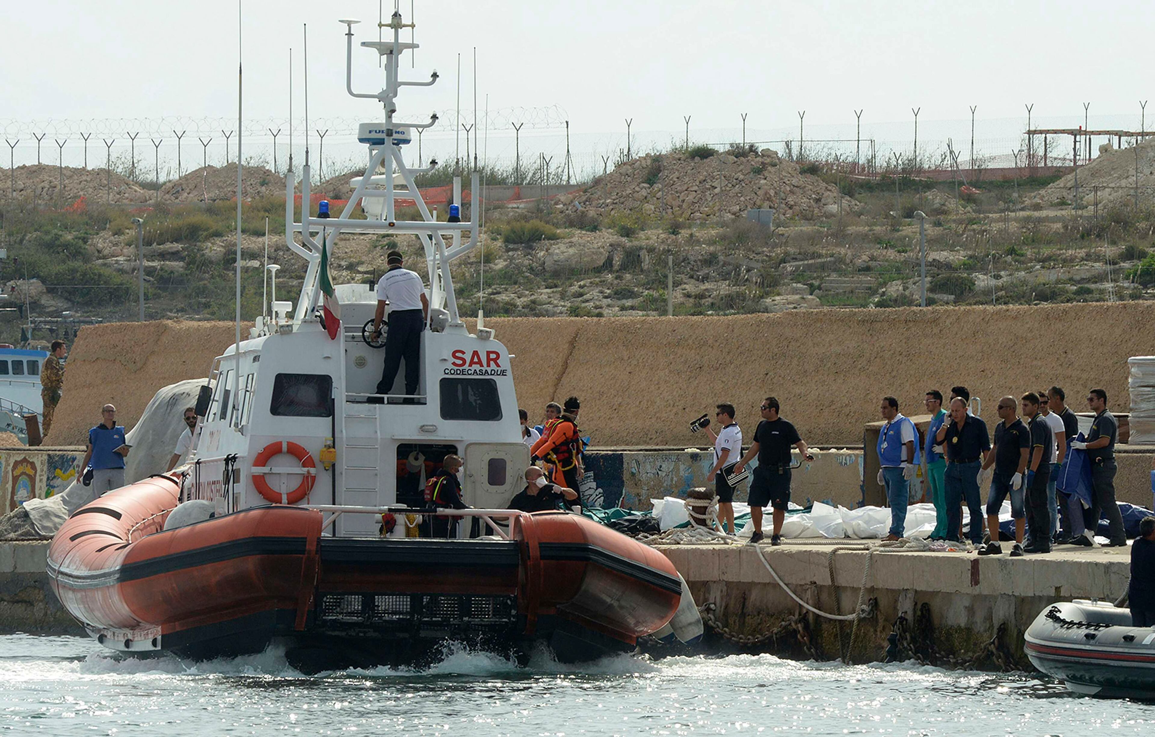 A coastguard vessel maneuvers after unloading body bags containing African migrants, who drowned trying to reach Italian shores, in the harbor of Lampedusa on Oct. 3, 2013.