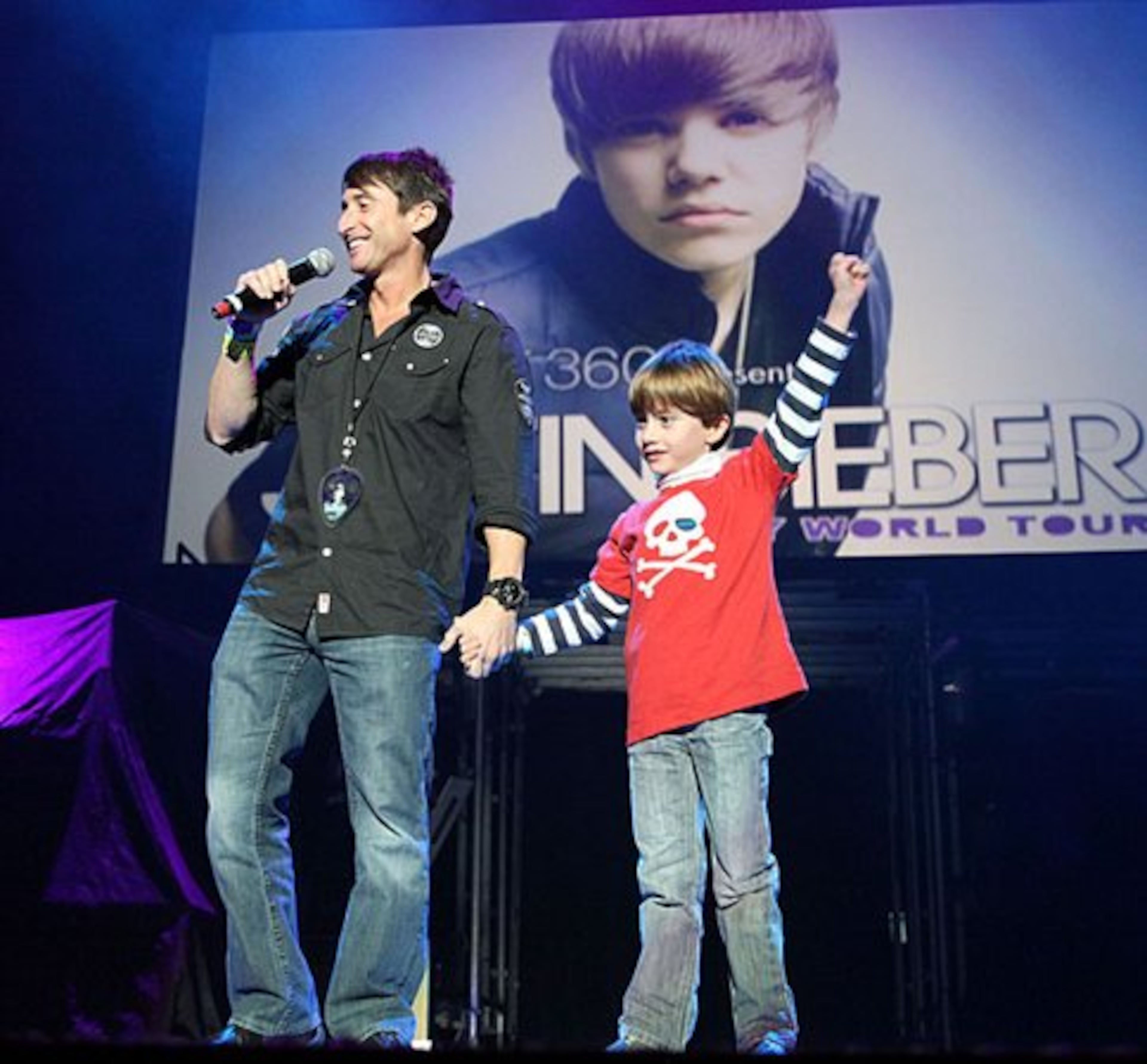 Q100's morning host Bert Weiss greets the crowd along with his 8-year old son in 2010.