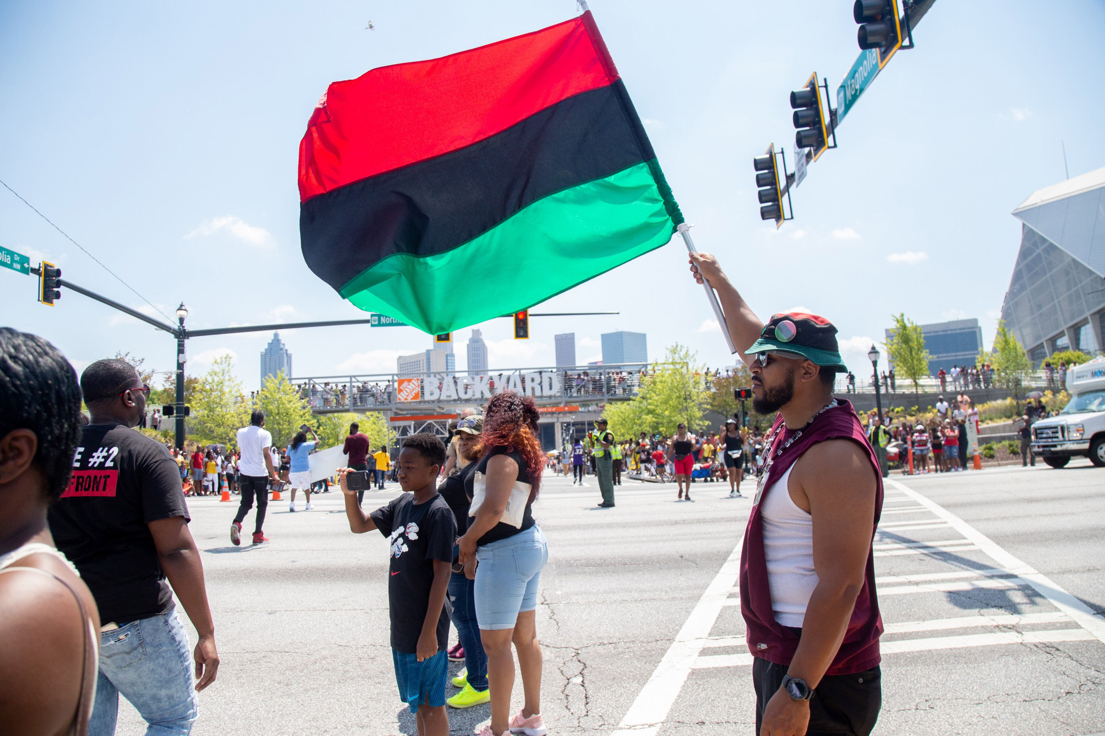 John Hargrove holds a UNIA flag as the parade makes its way into the Home Depot Backyard at the Mercedes-Benz Stadium during the Juneteenth Atlanta Black History Parade on Saturday, June 15, 2019. STEVE SCHAEFER / SPECIAL TO THE AJC