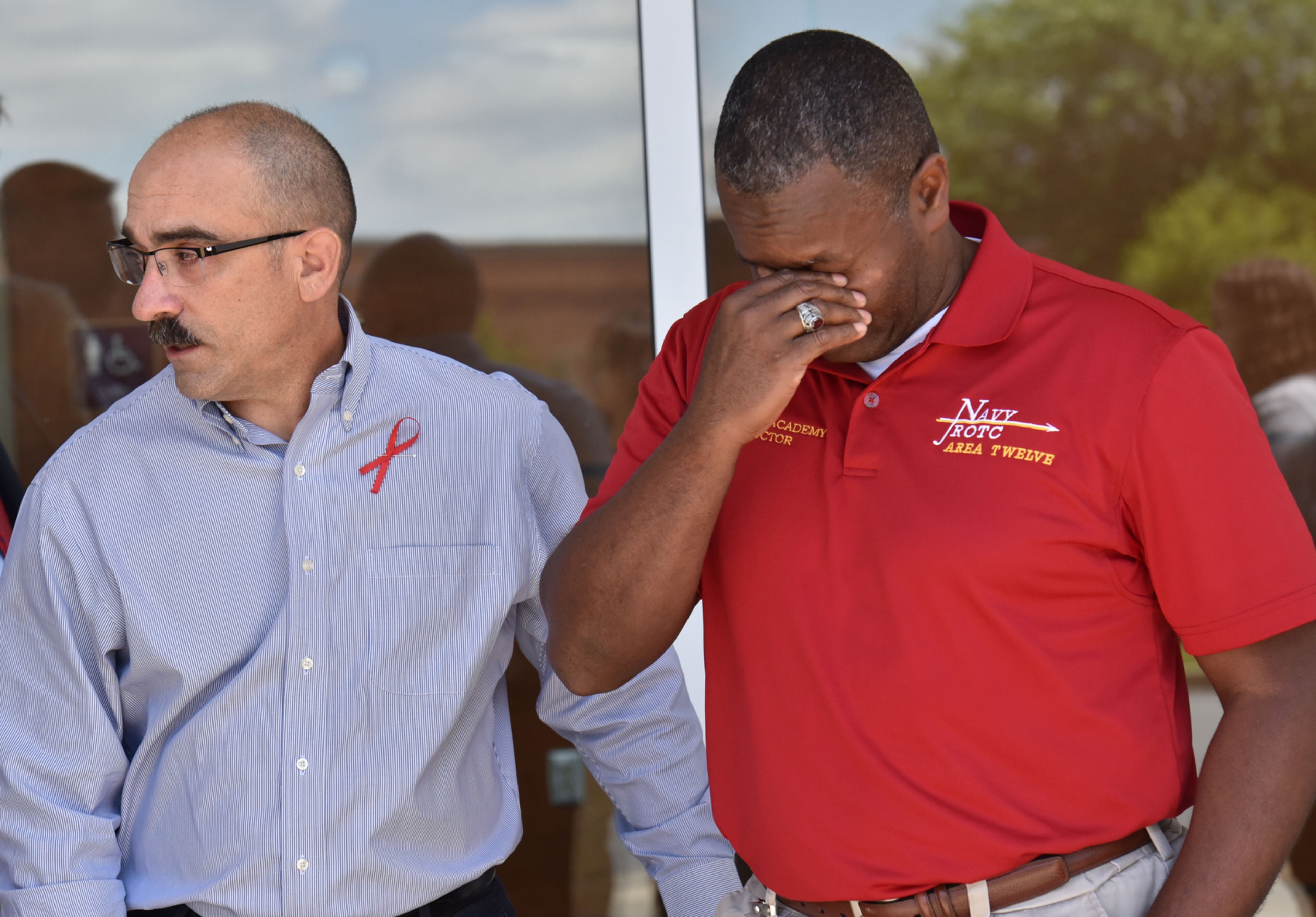 April 25, 2017 Roswell - Captain James Minta (left), Senior Naval Science Instructor, comforts 1st Sgt Lorenzo Cox, Naval Science Instructor, as he gets emotional for his students, who were killed when their vehicle struck a Fulton County school bus on Highway 92 on Monday, April 24, at Lassiter High School students on Tuesday, April 25, 2017. A Go Fund Me page has been created to help the family of Lassiter High School students James Irving Pratt, 18, (senior) and Joseph Thomas Pratt,14, (freshman), who were both killed when their vehicle struck a Fulton County school bus on Highway 92 on Monday, April 24. HYOSUB SHIN / HSHIN@AJC.COM