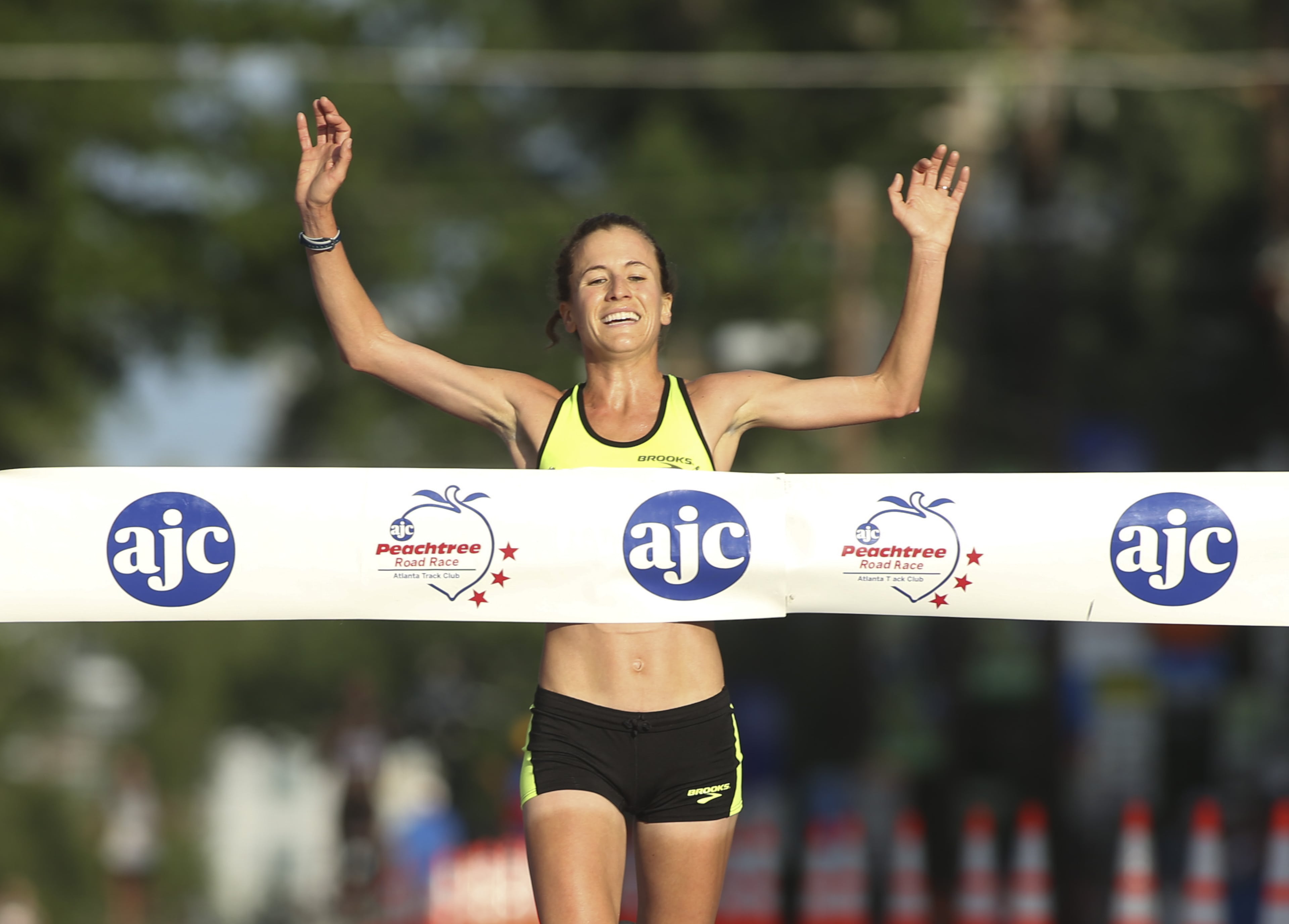 Amy Hastings celebrates as she crosses the finish line winning the Women's Field of the AJC Peachtree Road Race Friday morning July 4, 2014, in Atlanta, Ga.. PHOTO BY / JASON GETZ