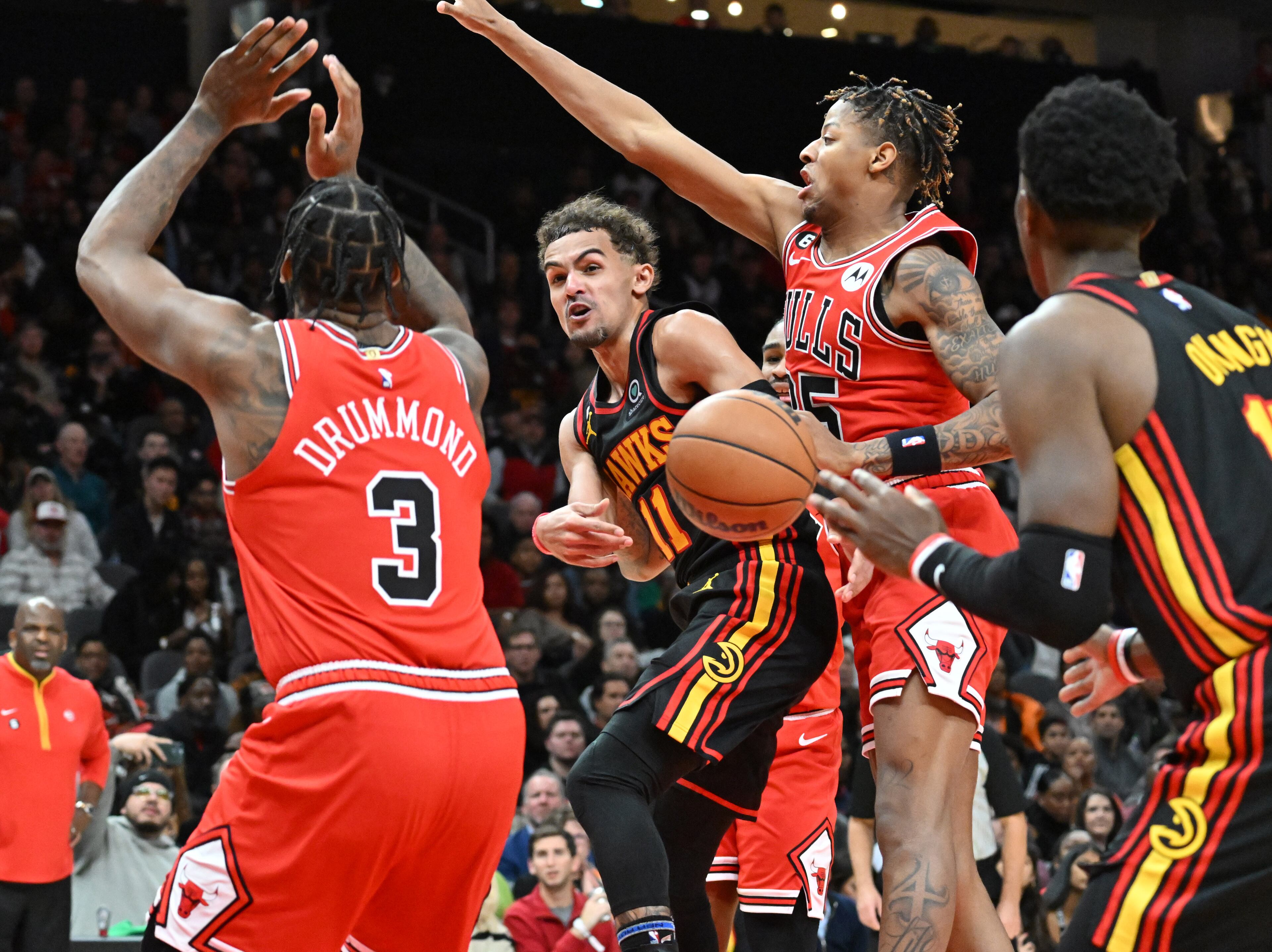 Hawks guard Trae Young (center) throws a pass to center Onyeka Okongwu (right) during the second half against the Bulls at State Farm Arena on Wednesday, Dec. 21, 2022. The Bulls won 110 - 108. (Hyosub Shin / Hyosub.Shin@ajc.com)