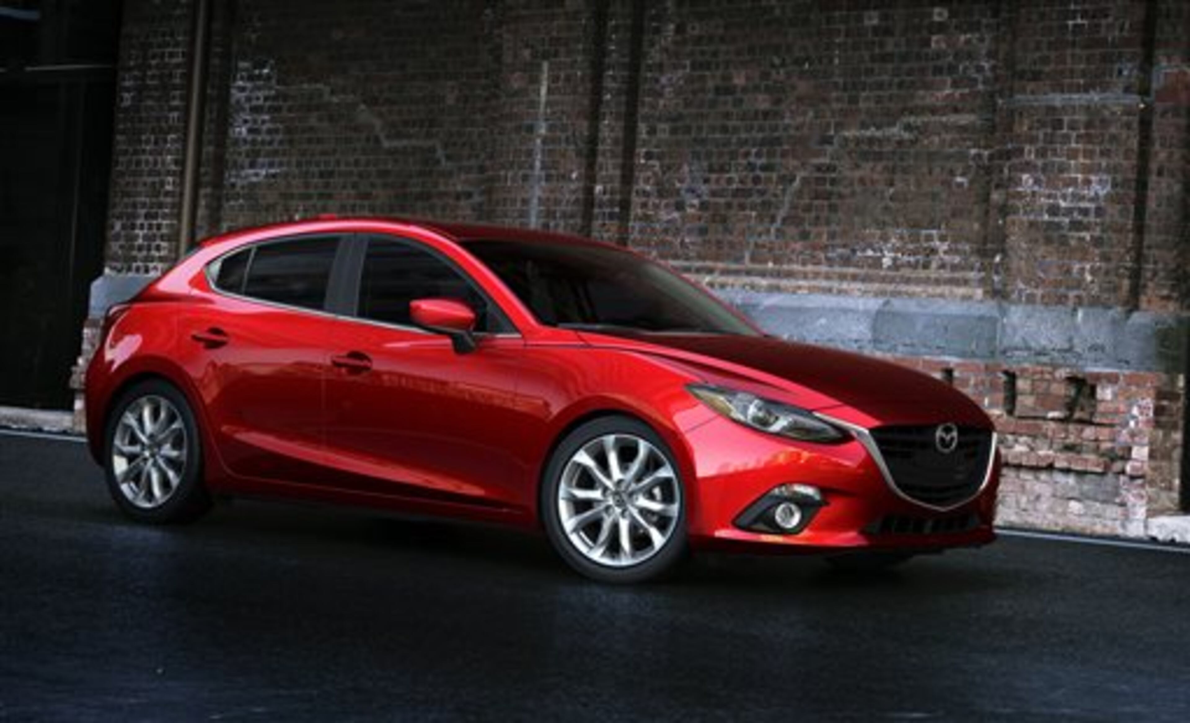 This publicity photo provided by Mazda North American Operations shows the 2014 Mazda3. The third generation Mazda3 small car, which goes on sale this fall, now has the same elegant swooping lines, elongated hood and narrow headlights of the larger Mazda6. The Mazda3 now has Mazda's Skyactiv suite of fuel-saving technologies, including which includes lighter materials and a more efficient engine. (AP Photo/Mazda North American Operations)
