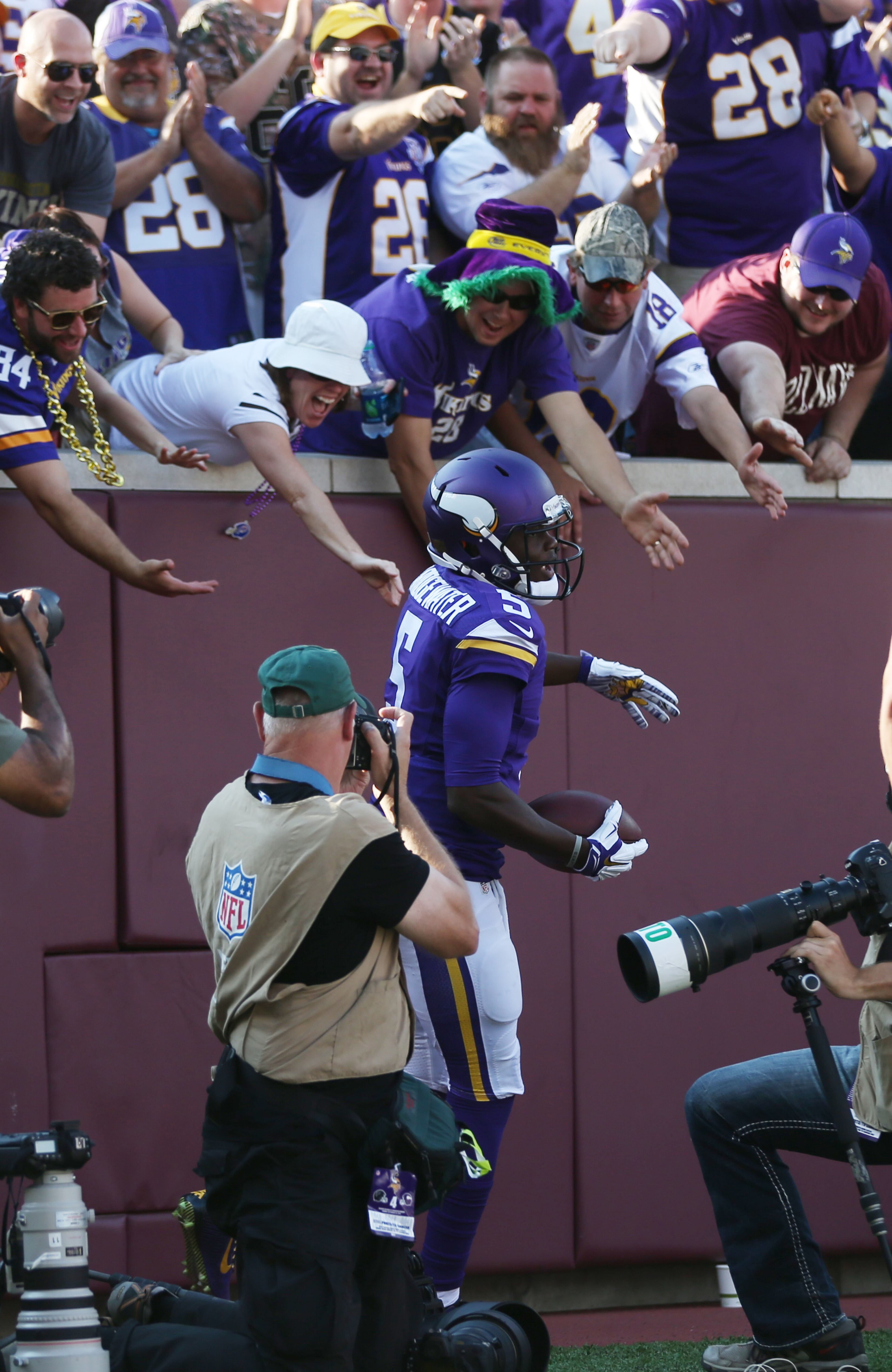 Minnesota Vikings quarterback Teddy Bridgewater (5) reacts to fans after a 13-yard touchdown run during the first half of an NFL football game against the Atlanta Falcons, Sunday, Sept. 28, 2014, in Minneapolis. (AP Photo/Jim Mone)