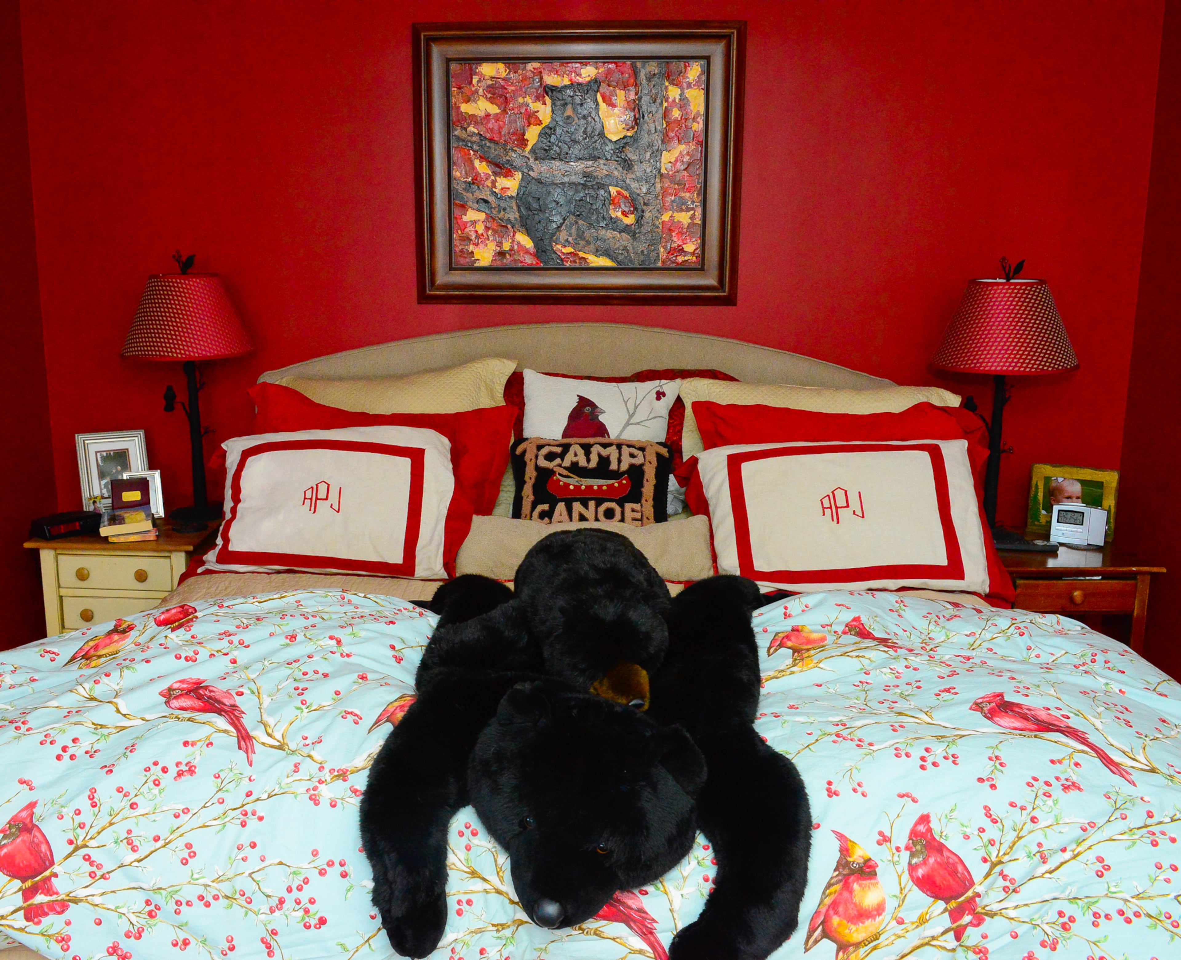 The colors of John and Andrea Pruitt's master bedroom were inspired by the painting by Ann Young. The bed features a burlap headboard and a Cardinal-themed quilt is from Crate and Barrel.