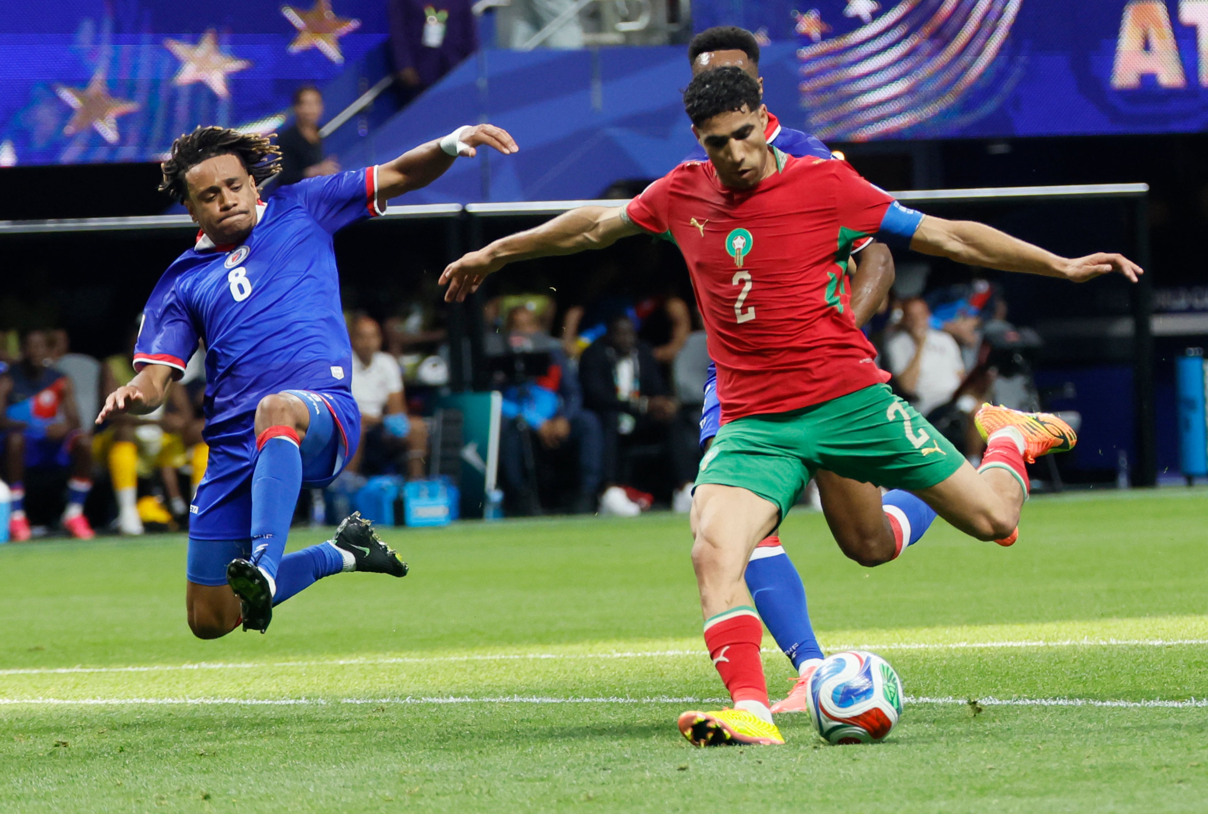 Morocco's Achraf Hakimi, right, takes a shot as Haiti's Martin Experience slides in to try and defend during first half of Morocco vs. Haiti Group C FIFA World Cup match at Atlanta Stadium (Mercedes-Benz Stadium) on Wednesday, June 24, 2026. (Miguel Martinez/AJC)