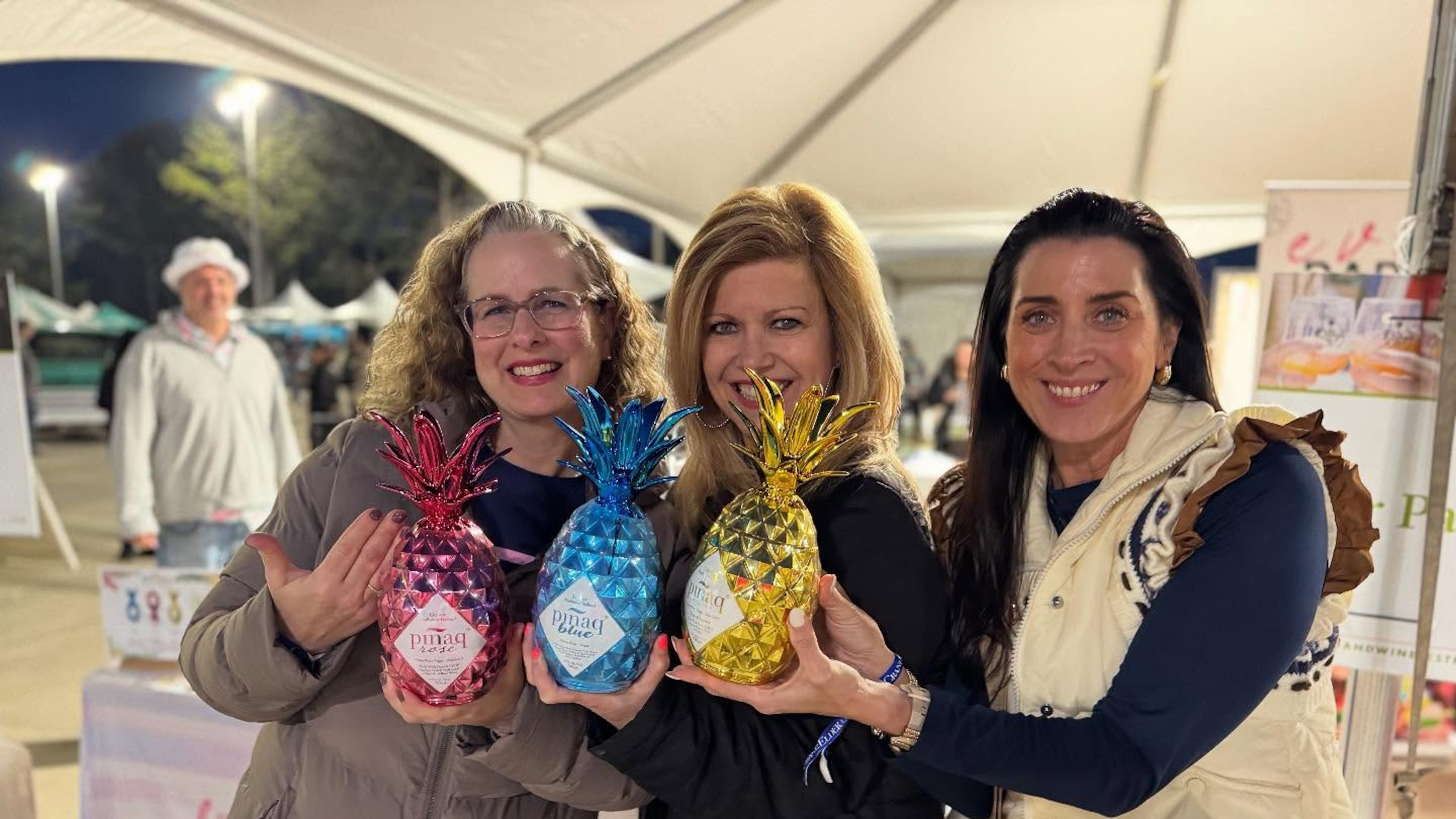 Visitors pose for a photograph in the Georgia Grown village at the Georgia Food + Wine Festival 2025. There, you’ll find jams, sauces, candles, soaps, and packaged goods for sale. (Courtesy of the Georgia Food + Wine Festival)