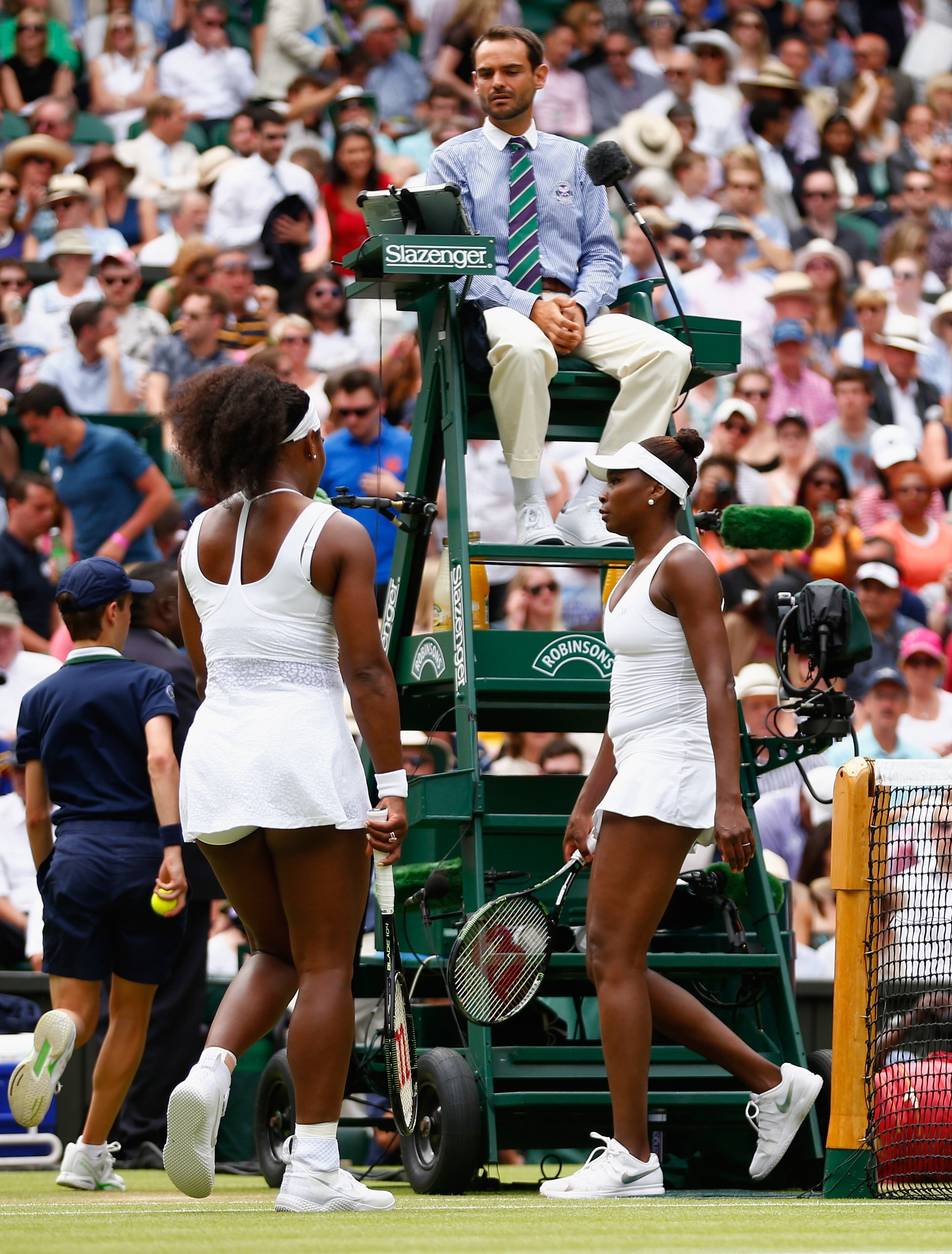 Serena Williams of the United States and Venus Williams of the United States swap ends during their Ladies' Singles Fourth Round match during day seven of the Wimbledon Lawn Tennis Championships at the All England Lawn Tennis and Croquet Club on July 6, 2015 in London, England. (Photo by Julian Finney/Getty Images)