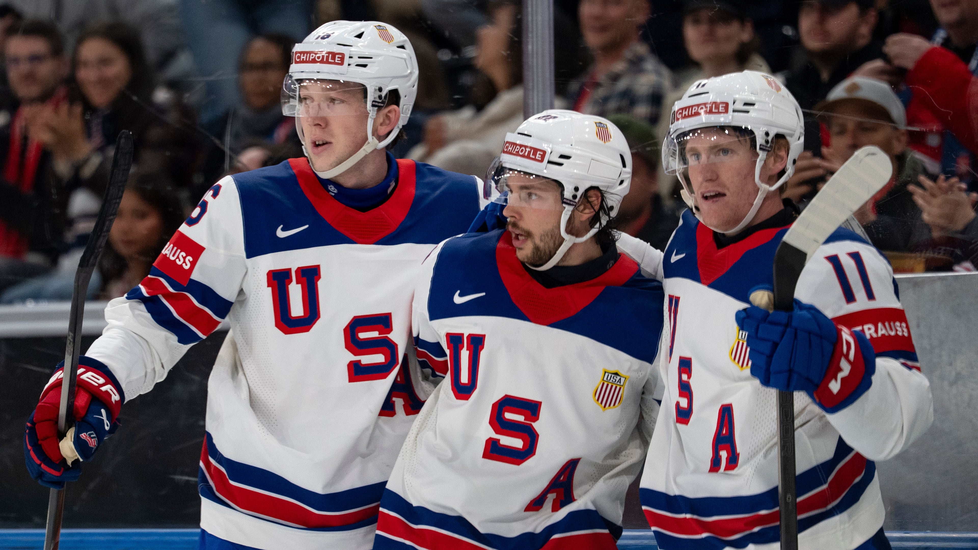 From left, USA's Mason Lohrei, Isaac Howard and Oliver Moore celebrate after their team's second goal, during the 2026 IIHF Men's Ice Hockey World Championship preliminary round group A game between Britain and the United States, in Zurich, Switzerland, Sunday, May 17, 2026. (Claudio Thoma/Keystone via AP)