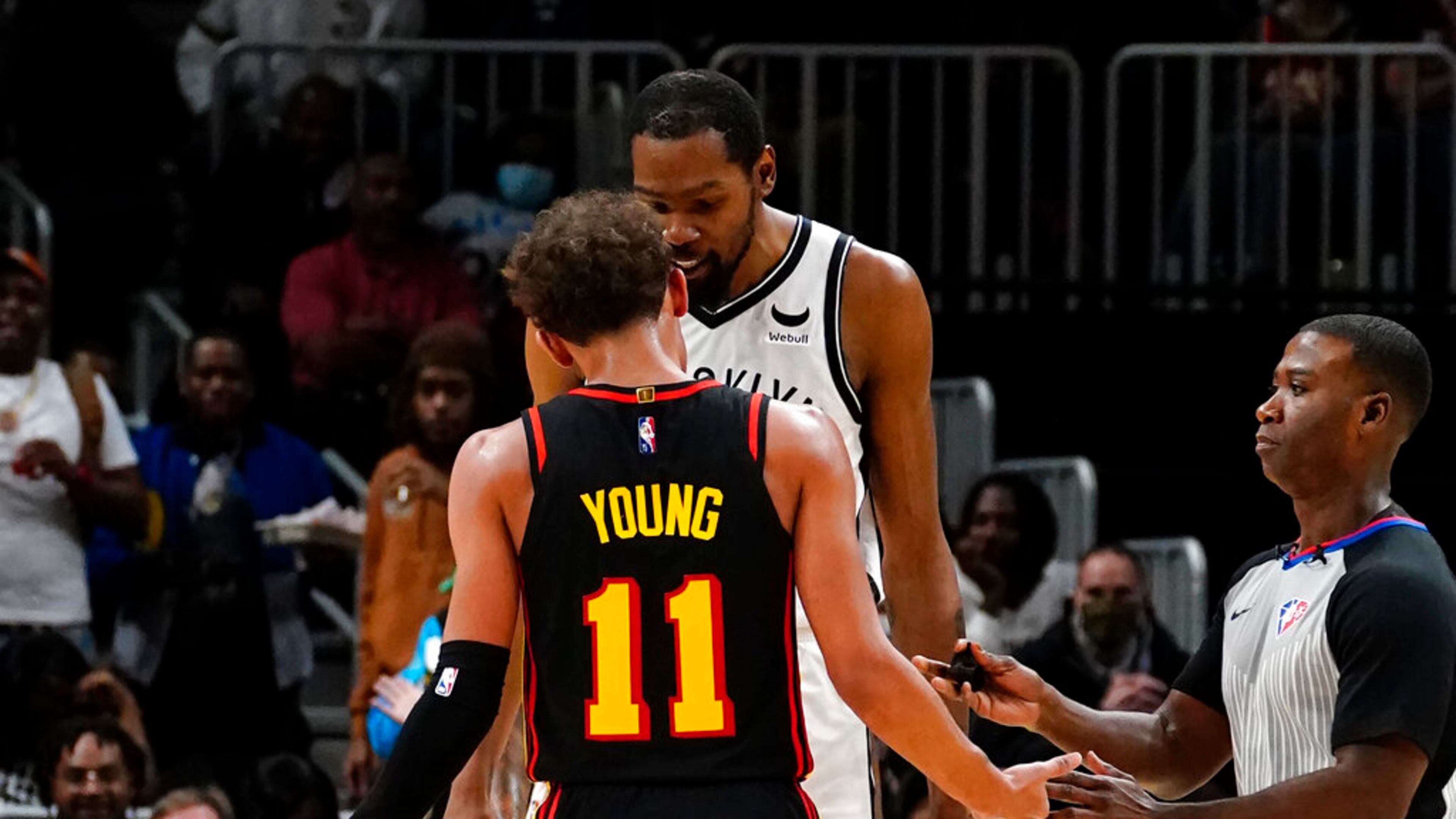 Atlanta Hawks guard Trae Young (11) and Brooklyn Nets forward Kevin Durant exchange words during the second half of an NBA basketball game Friday, Dec. 10, 2021, in Atlanta. (AP Photo/John Bazemore)