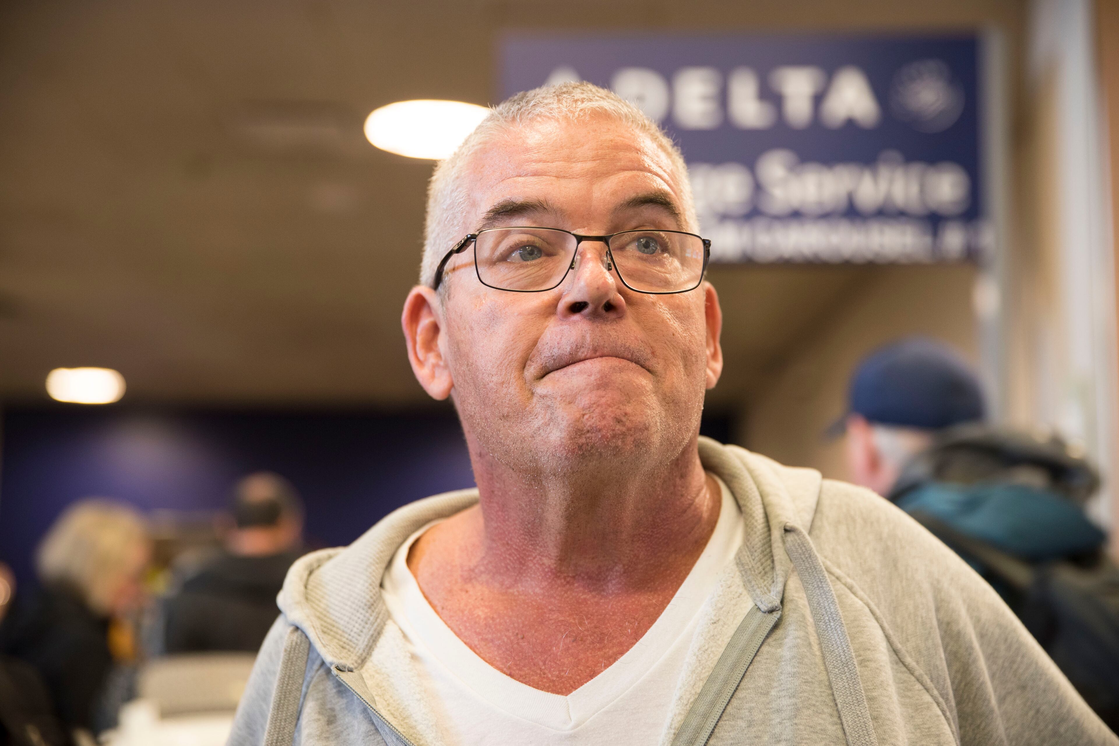 James Flynn, of Acworth, finally got to his elderly mother-in-law Sunday afternoon after she was stranded on the tarmac for hours. (Alyssa Pointer/AJC)