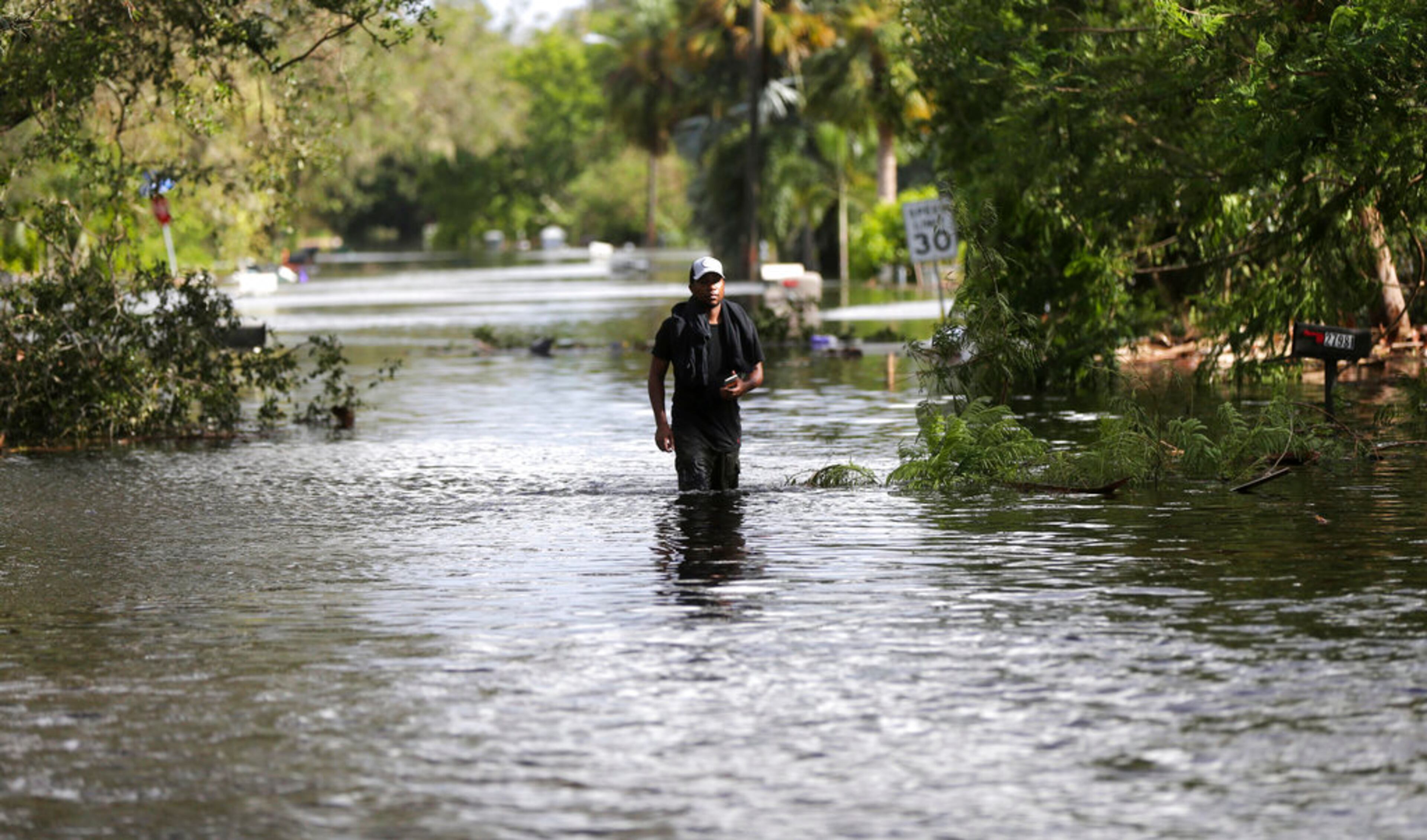 Rhori Cameron walks though his flooded neighborhood, in the aftermath of Hurricane Irma in Bonita Springs, Fla., Monday, Sept. 11, 2017. (AP Photo/Gerald Herbert)