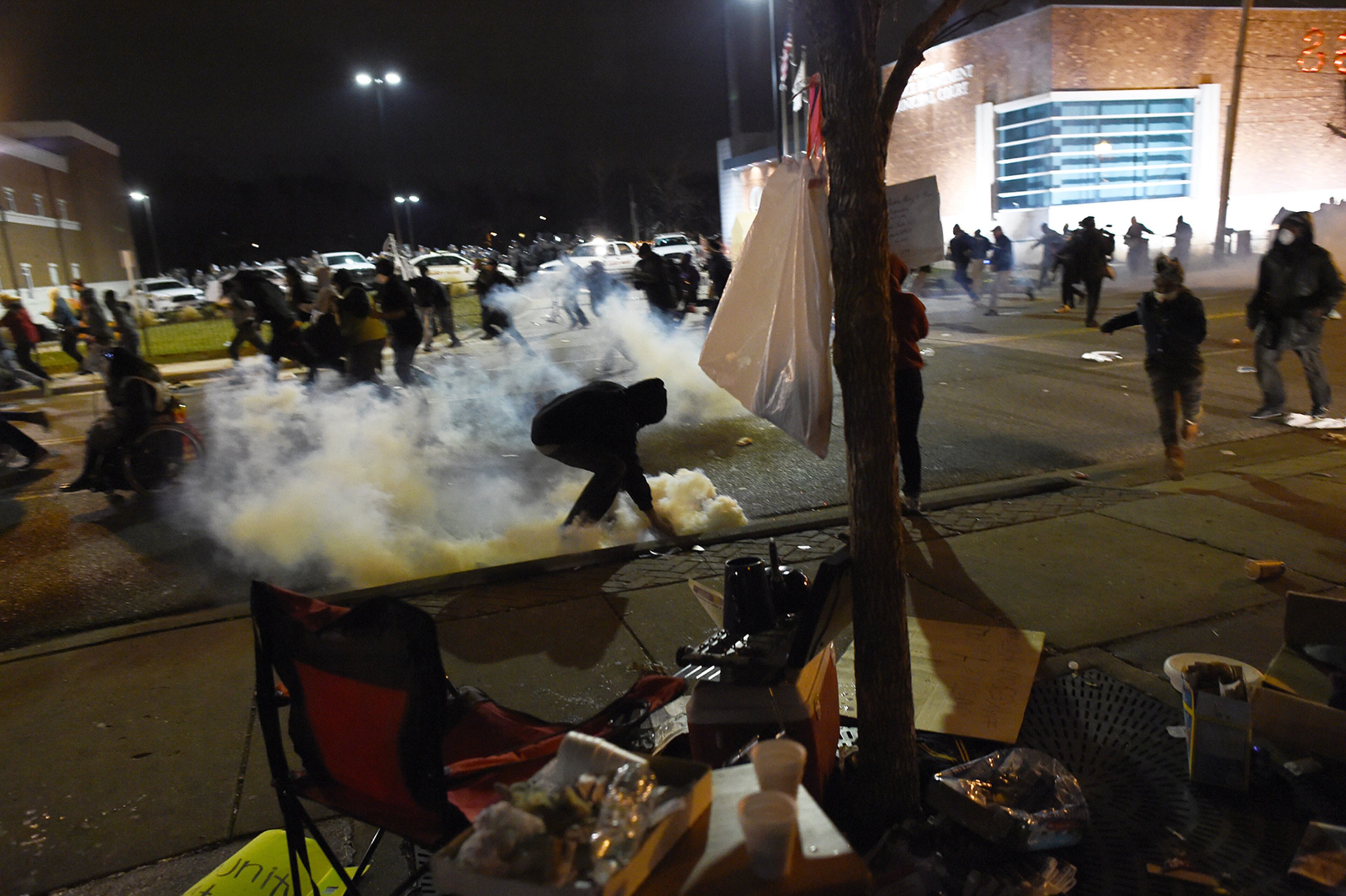 Demonstrators flee as police fire tear gas during a demonstration to protest the death of 18-year-old Michael Brown in Ferguson, Missouri, on November 24, 2014. US President Barack Obama urged calm as violent protests broke out on the streets of Ferguson after a grand jury decided a white policeman will not face charges for killing a black teen. AFP PHOTO/Jewel Samad (Photo credit should read JEWEL SAMAD/AFP/Getty Images)