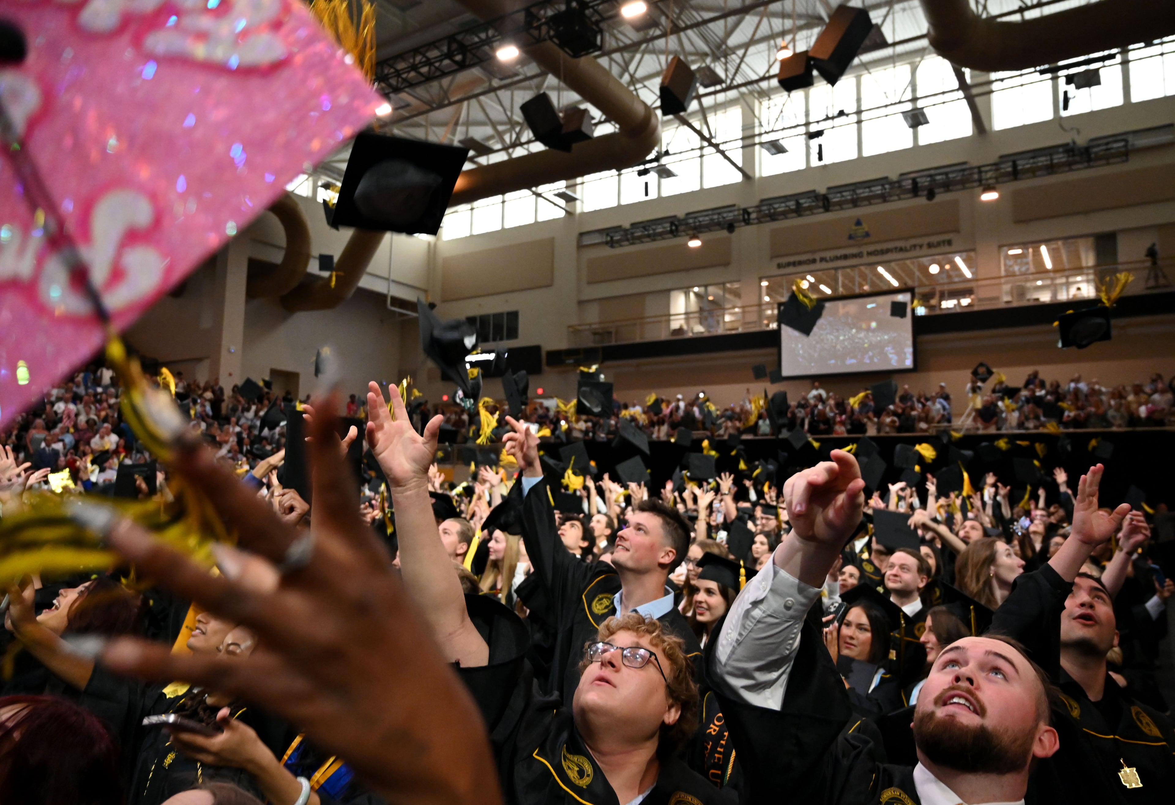 Graduates toss their caps during Kennesaw State University’s spring commencement at the KSU Convocation Center on May 13, 2026. The ceremony included the College of Architecture and Construction Management, and the Michael J. Coles College of Business (undergraduate students in entrepreneurship, hospitality, management, marketing and professional sales). (Hyosub Shin/AJC)