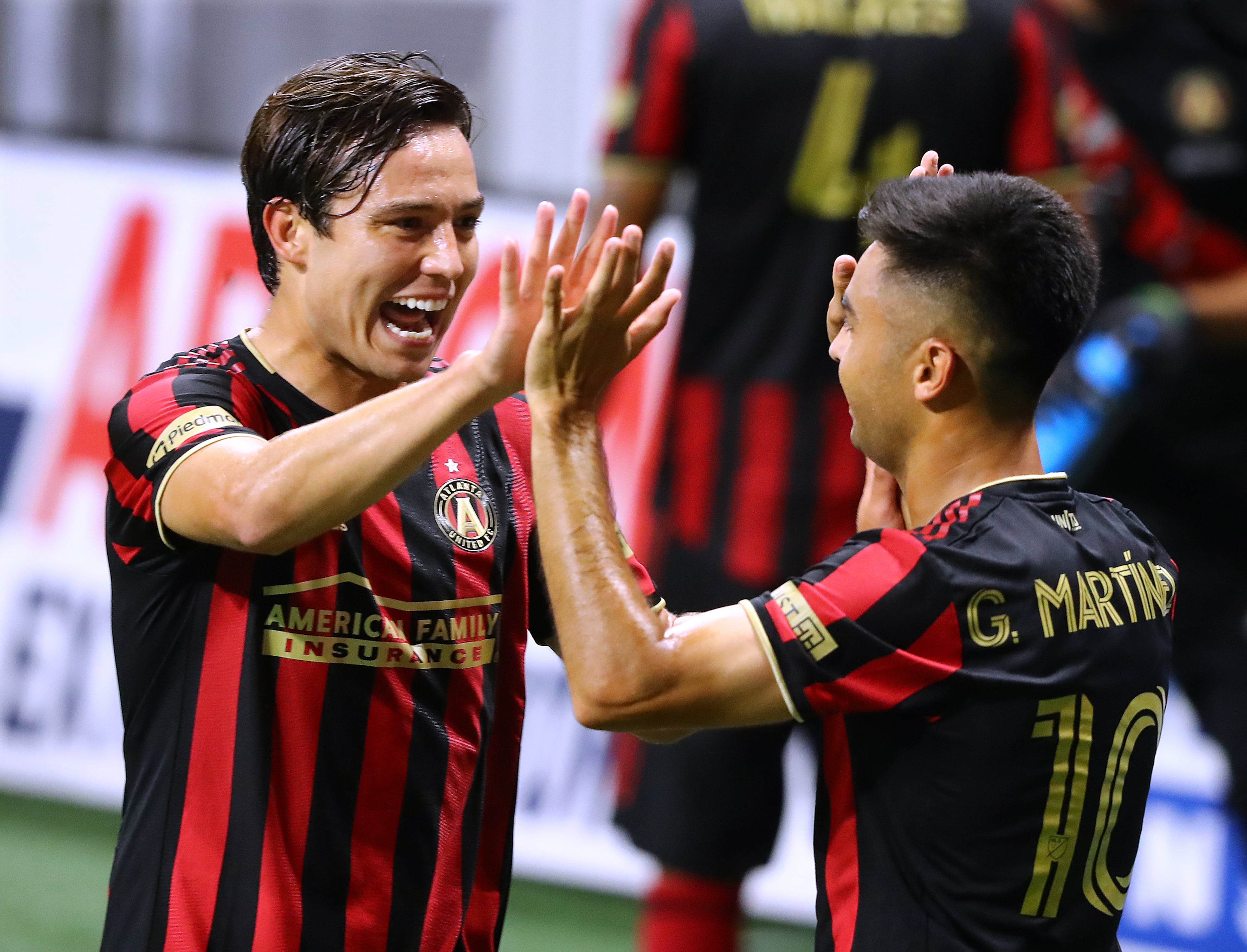 Atlanta United forward Erick Torres (left) gives midfielder Pity Martinez a double high five after Martinez scored his second goal of the night against Nashville SC during the second half for the 2-0 victory in a MLS soccer match on Saturday, August 22, 2020 in Atlanta. Curtis Compton ccompton@ajc.com