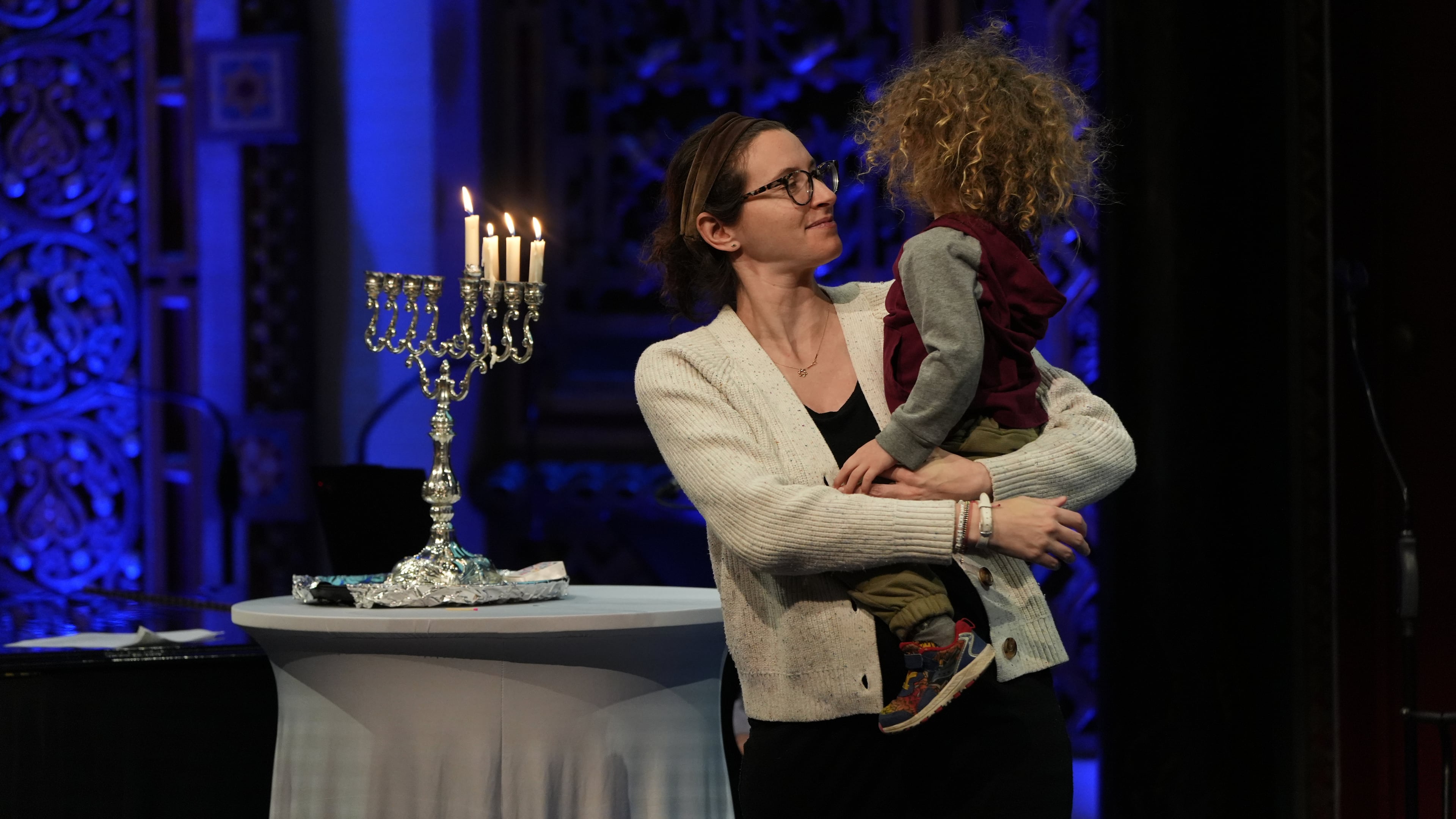 Rebecca Weintraub, assistant rabbi of New York City's B'nai Jeshurun congregation, holds her son during a Hannukah party at the synagogue on Tuesday, Dec. 16, 2025. (AP Photo/Luis Andres Henao)