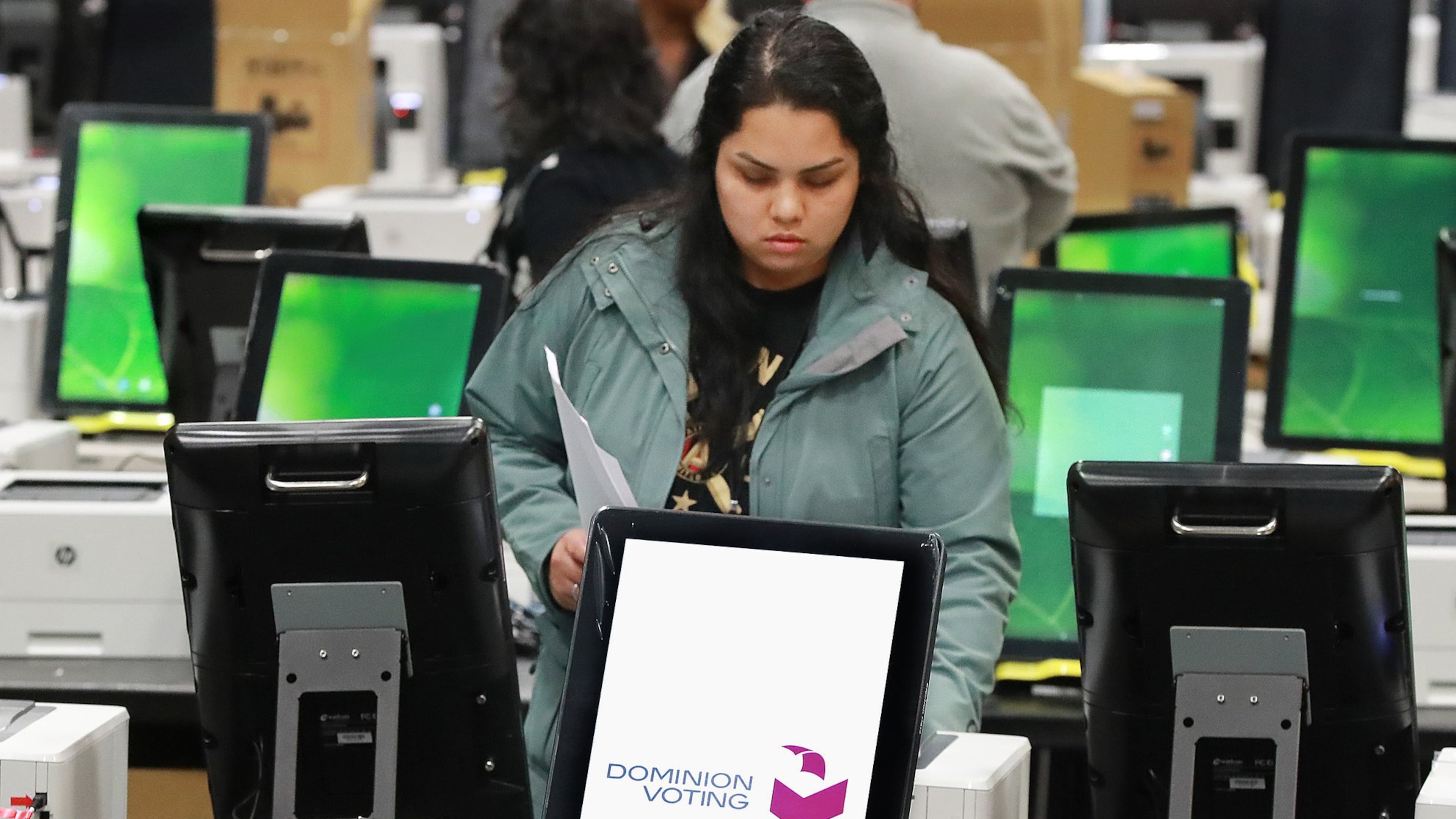 A worker helps test and pack thousands of Georgia’s new voting machines last month in a metro Atlanta warehouse. Curtis Compton ccompton@ajc.com