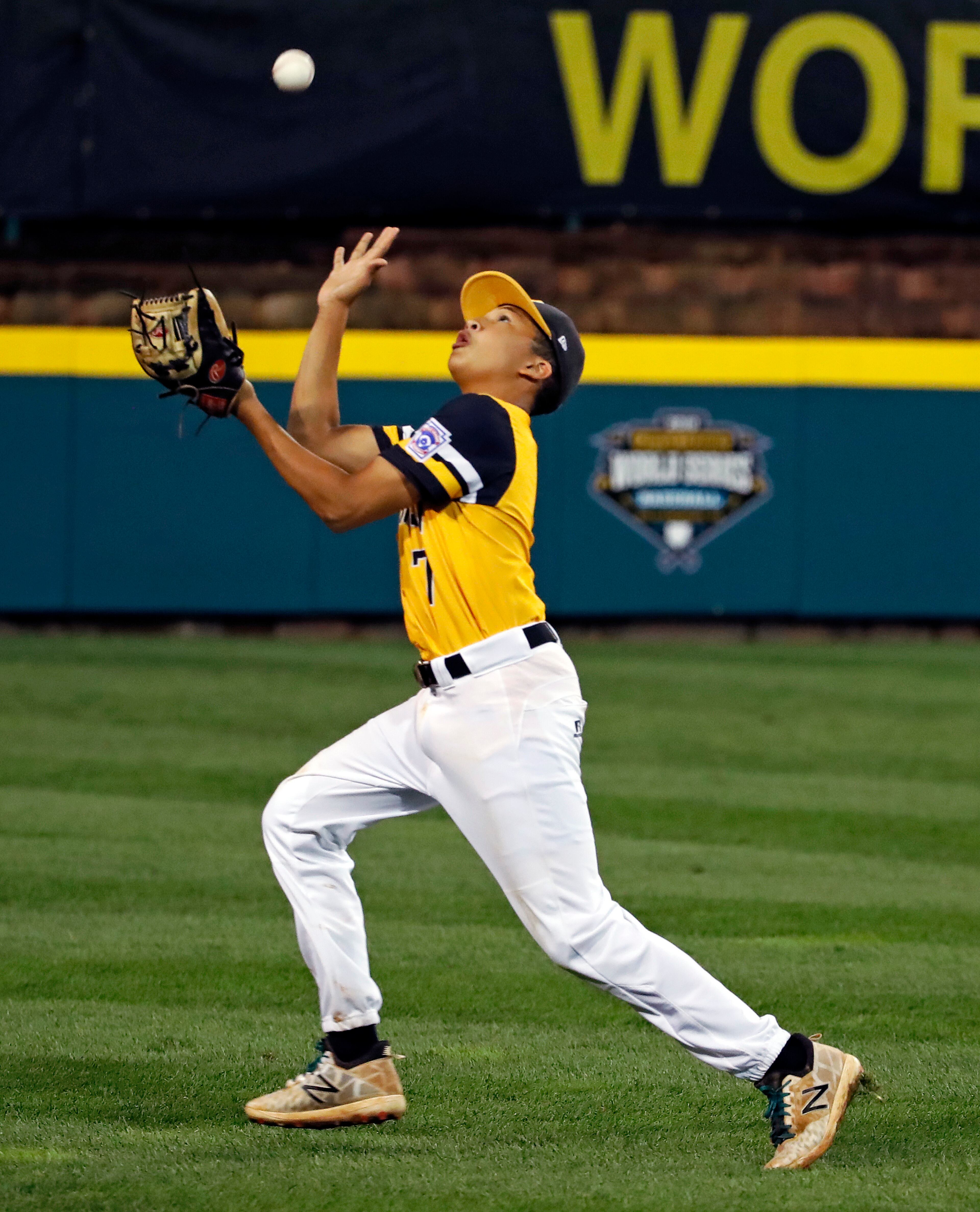 Peachtree City, Georgia, shortstop Tai Peete cannot get under a fly ball into short left field by Coeur d'Alene, Idaho's Cooper Smith in the fourth inning of an elimination baseball game in United States pool play at the Little League World Series tournament in South Williamsport, Pa., Saturday, Aug. 18, 2018. (AP Photo/Gene J. Puskar)