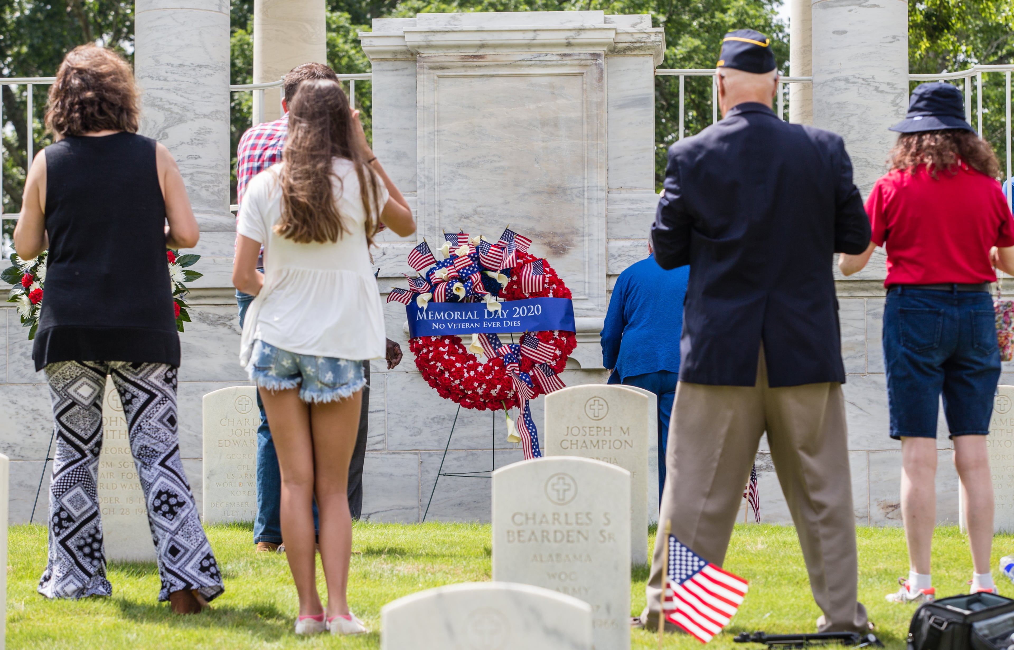 The Marietta National Cemetery did not hold official ceremonies this year, however, small groups gathered to watch the four Blackhawk helicopter flyover on Memorial Day, Monday, May 25, 2020. (Jenni Girtman for The Atlanta Journal Constitution)