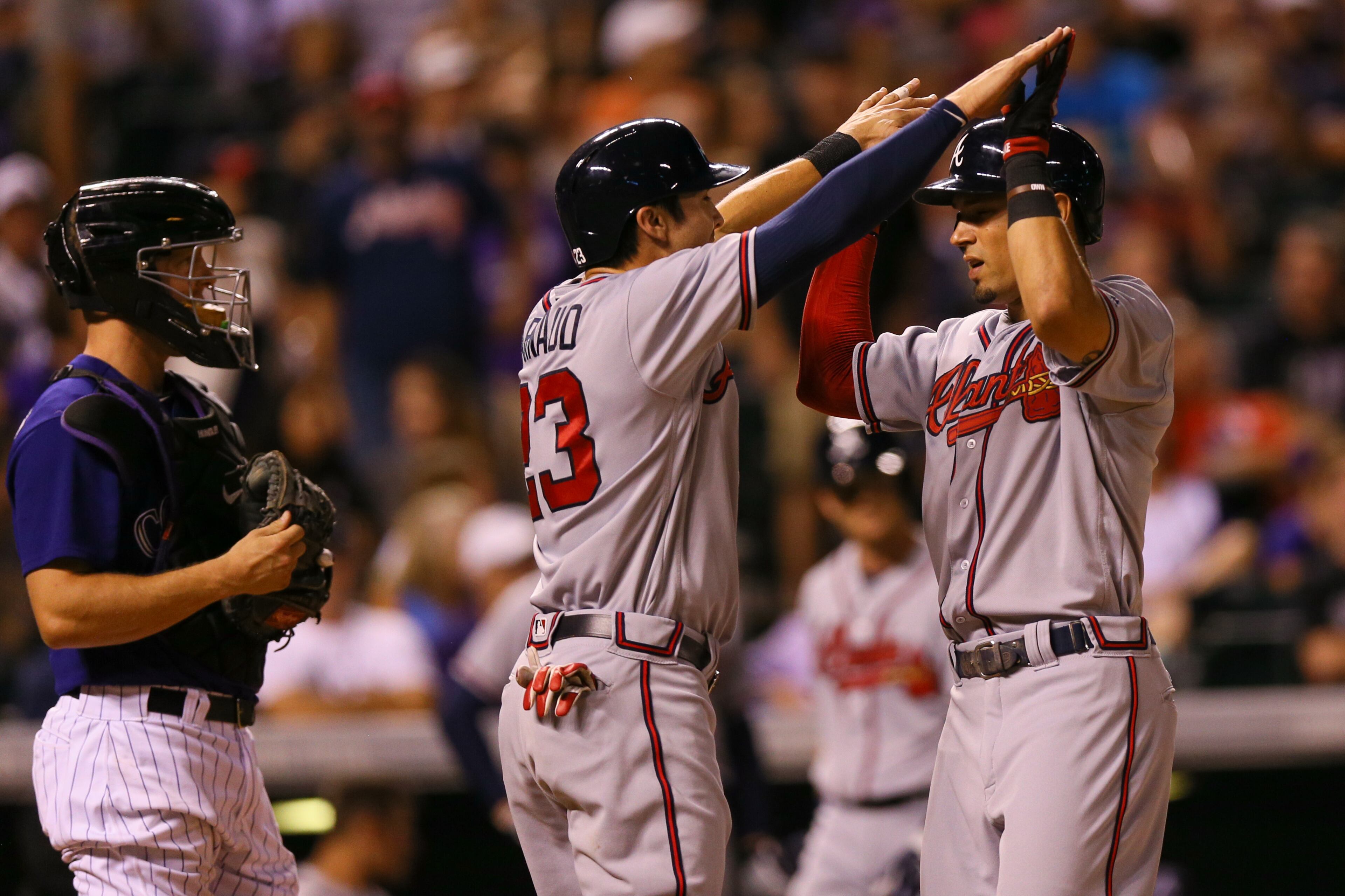 DENVER, CO - JULY 22: Jace Peterson #8 of the Atlanta Braves celebrates his two run home run with Chase d'Arnaud #23 as catcher Nick Hundley #4 of the Colorado Rockies looks on during the eighth inning at Coors Field on July 22, 2016 in Denver, Colorado. (Photo by Justin Edmonds/Getty Images)