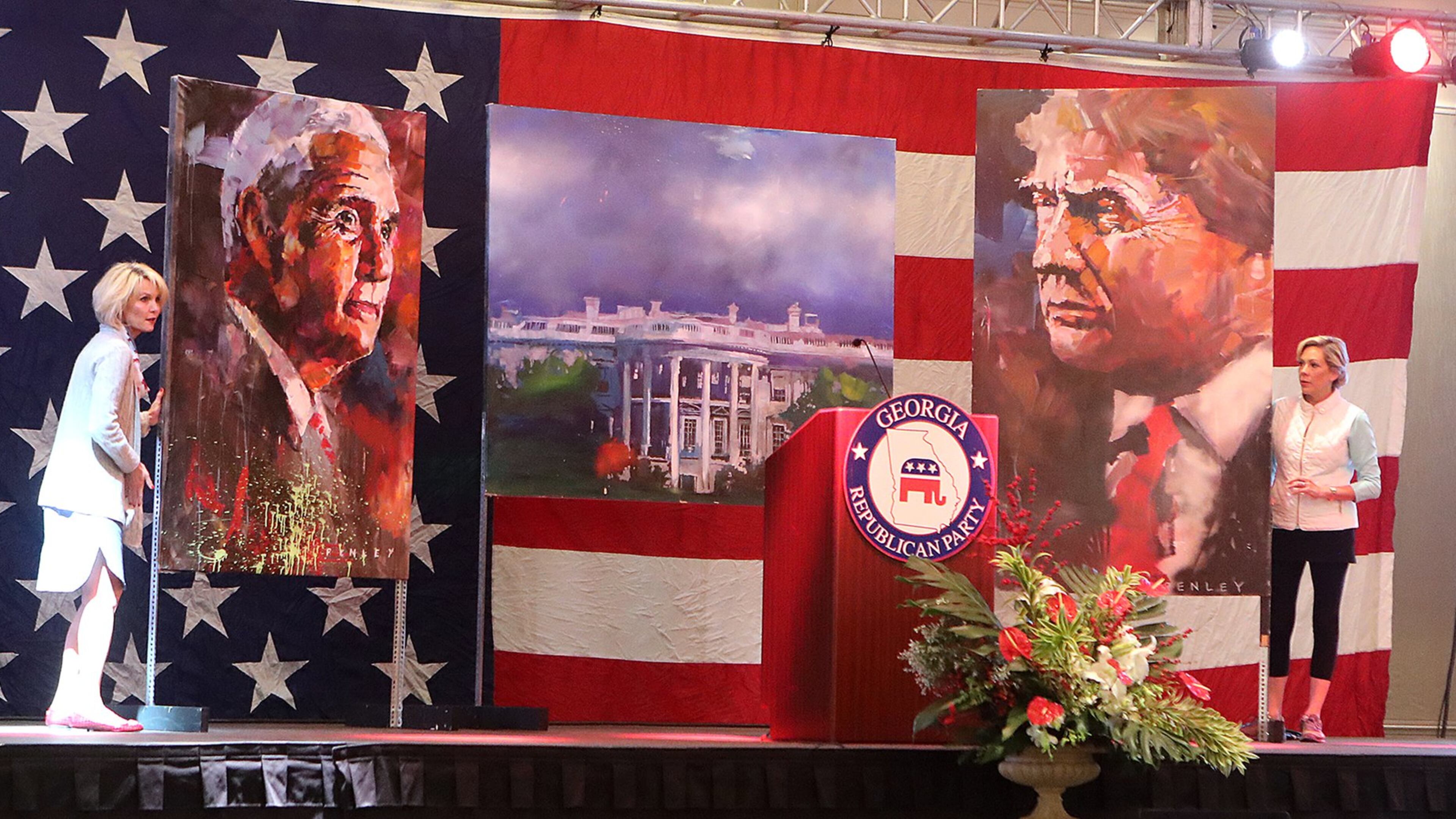 Ginger Howard (left) and Lee Anne Cowart set the stage with paintings of Donald Trump and Mike Pence for the Republican watch party Tuesday at the Grand Hyatt in Buckhead. Curtis Compton /ccompton@ajc.com