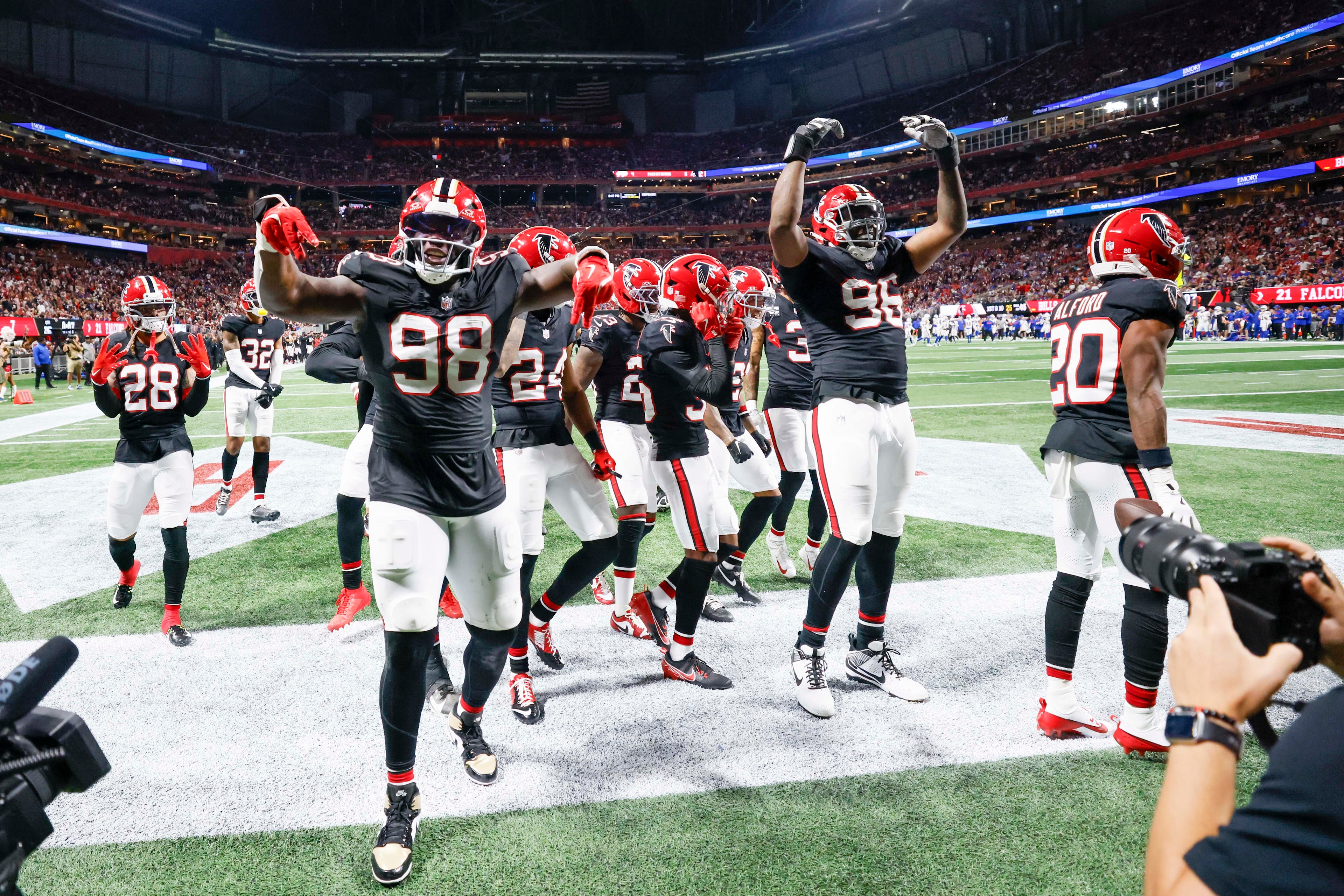Falcons players celebrate after Atlanta Falcons cornerback Dee Alford (right) intercepts the ball at the end of the first half of an NFL game against the Buffalo Bills at Mercedes-Benz Stadium in Atlanta on Monday, October 13, 2025. (Miguel Martinez/AJC)