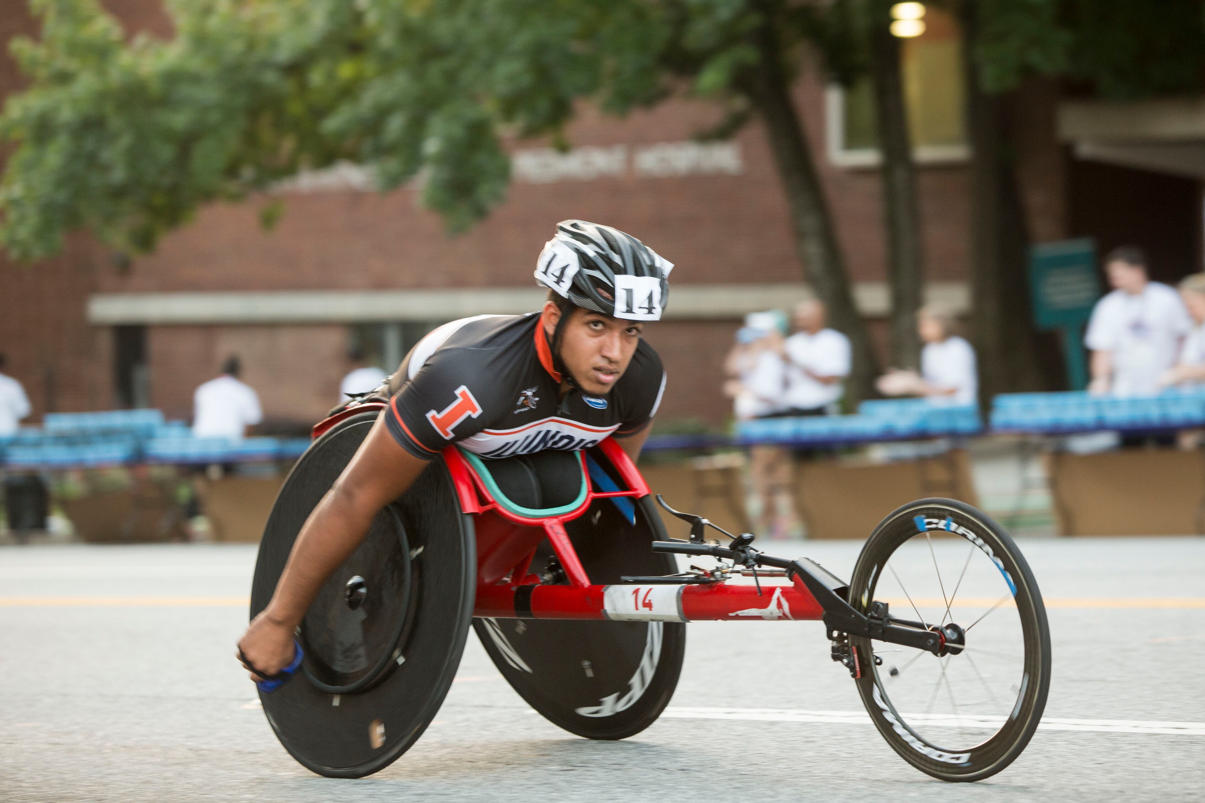 A participant in the Peachtree Road Race's first event, the 6:43 a.m Wheelchair Race, zooms up the infamous Cardiac Hill. Chad Rhym/ Chad.Rhym@ajc.com