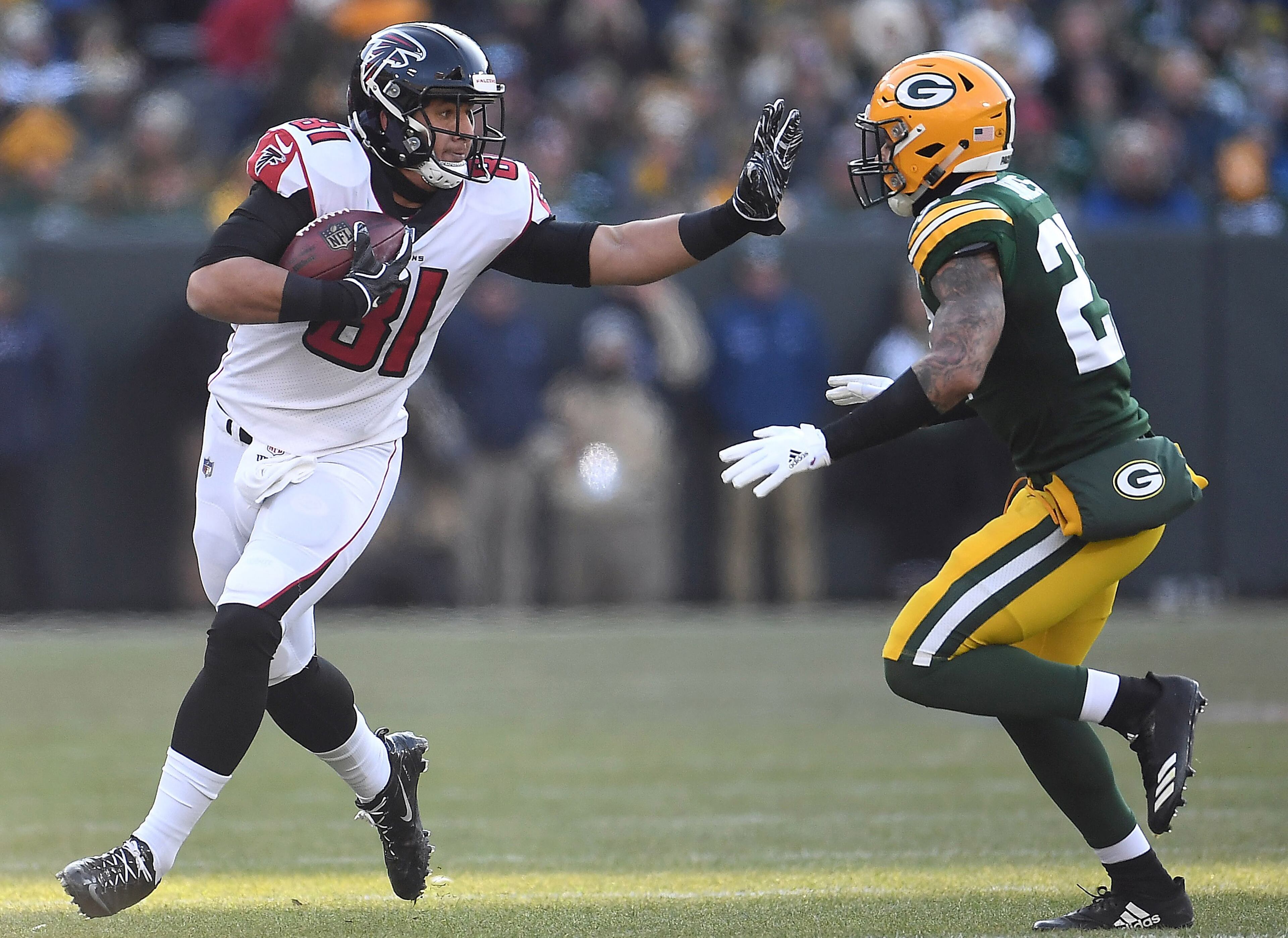 GREEN BAY, WISCONSIN - DECEMBER 09: Austin Hooper #81 of the Atlanta Falcons stiff arms Josh Jones #27 of the Green Bay Packers during the first half of a game at Lambeau Field on December 09, 2018 in Green Bay, Wisconsin. (Photo by Stacy Revere/Getty Images)
