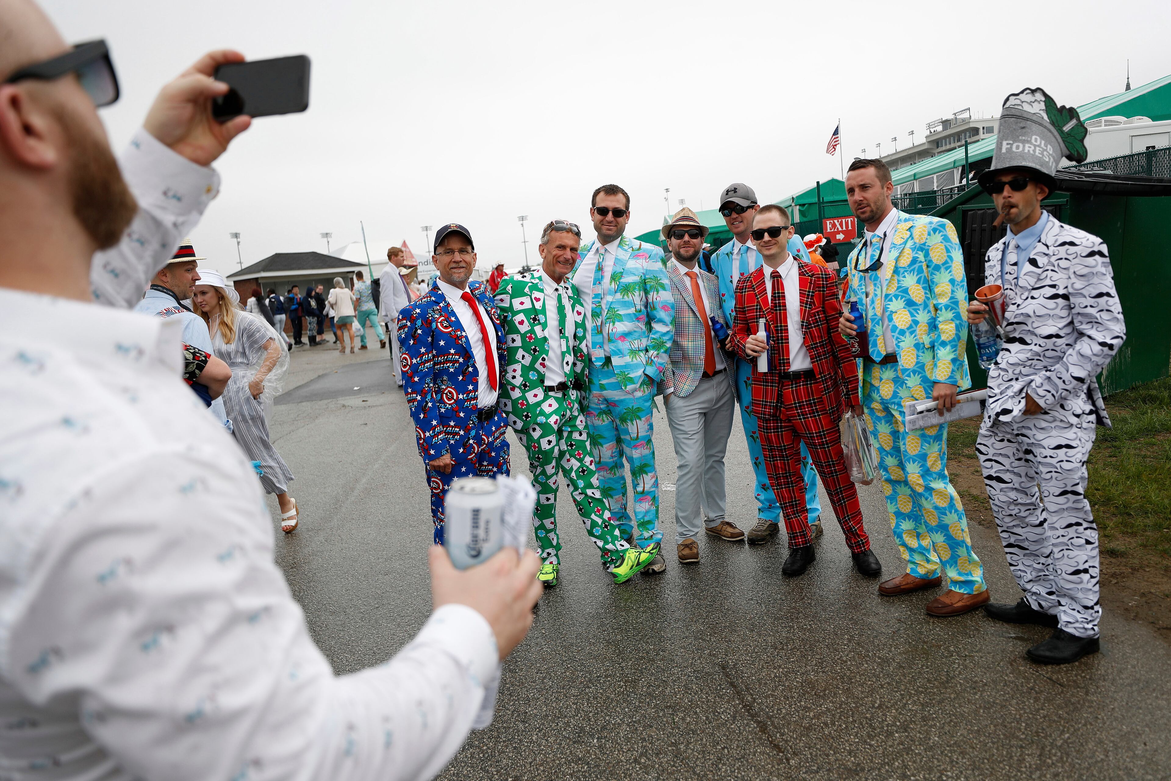 Men wear colorful suits in the infield before the 144th running of the Kentucky Derby horse race at Churchill Downs Saturday, May 5, 2018, in Louisville, Ky. (AP Photo/John Minchillo)