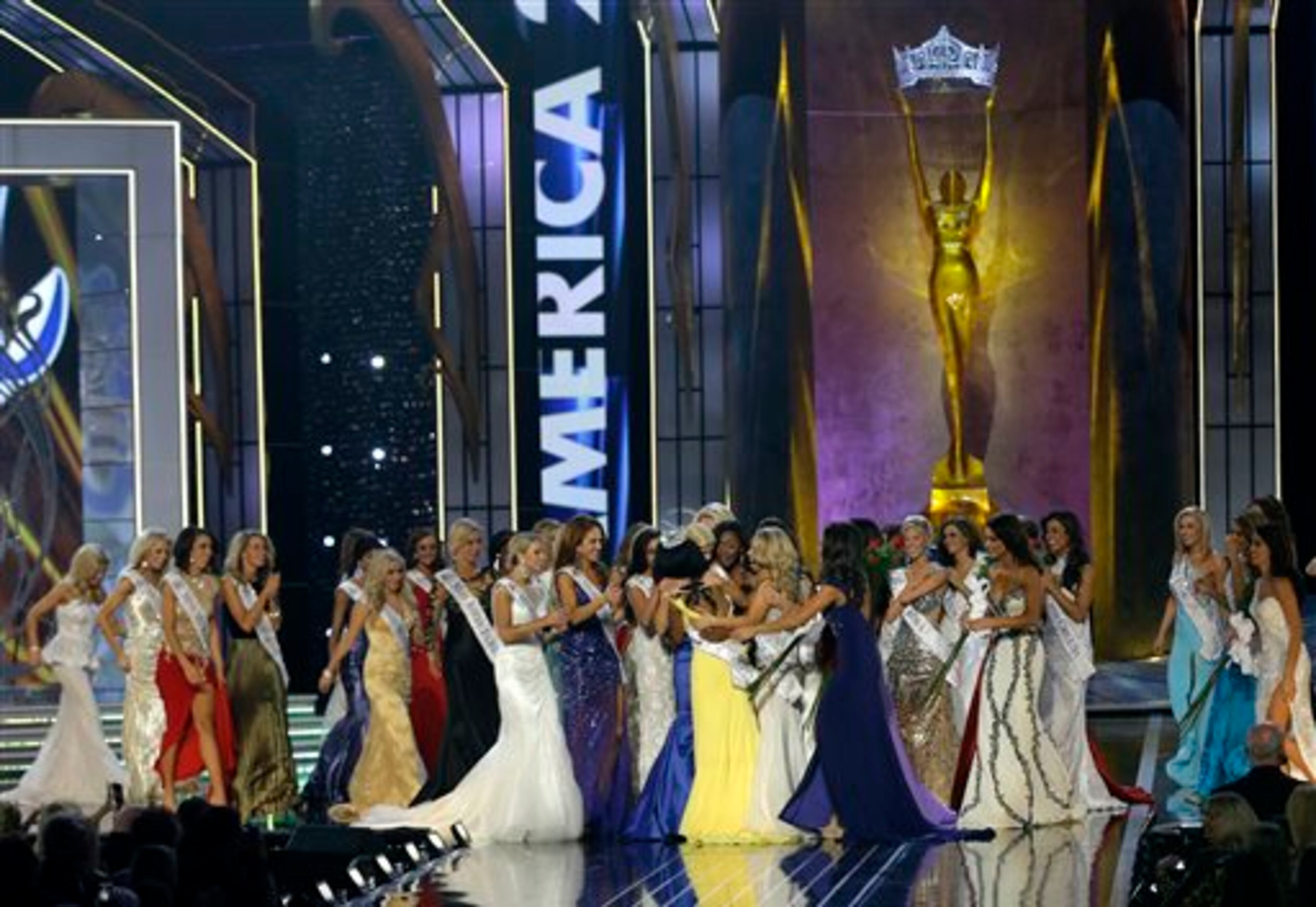 Miss New York Nina Davuluri, center left in yellow, is approached by contestants after Davuluri was crowned as Miss America 2014, Sunday, Sept. 15, 2013, in Atlantic City, N.J. (AP Photo/Mel Evans)