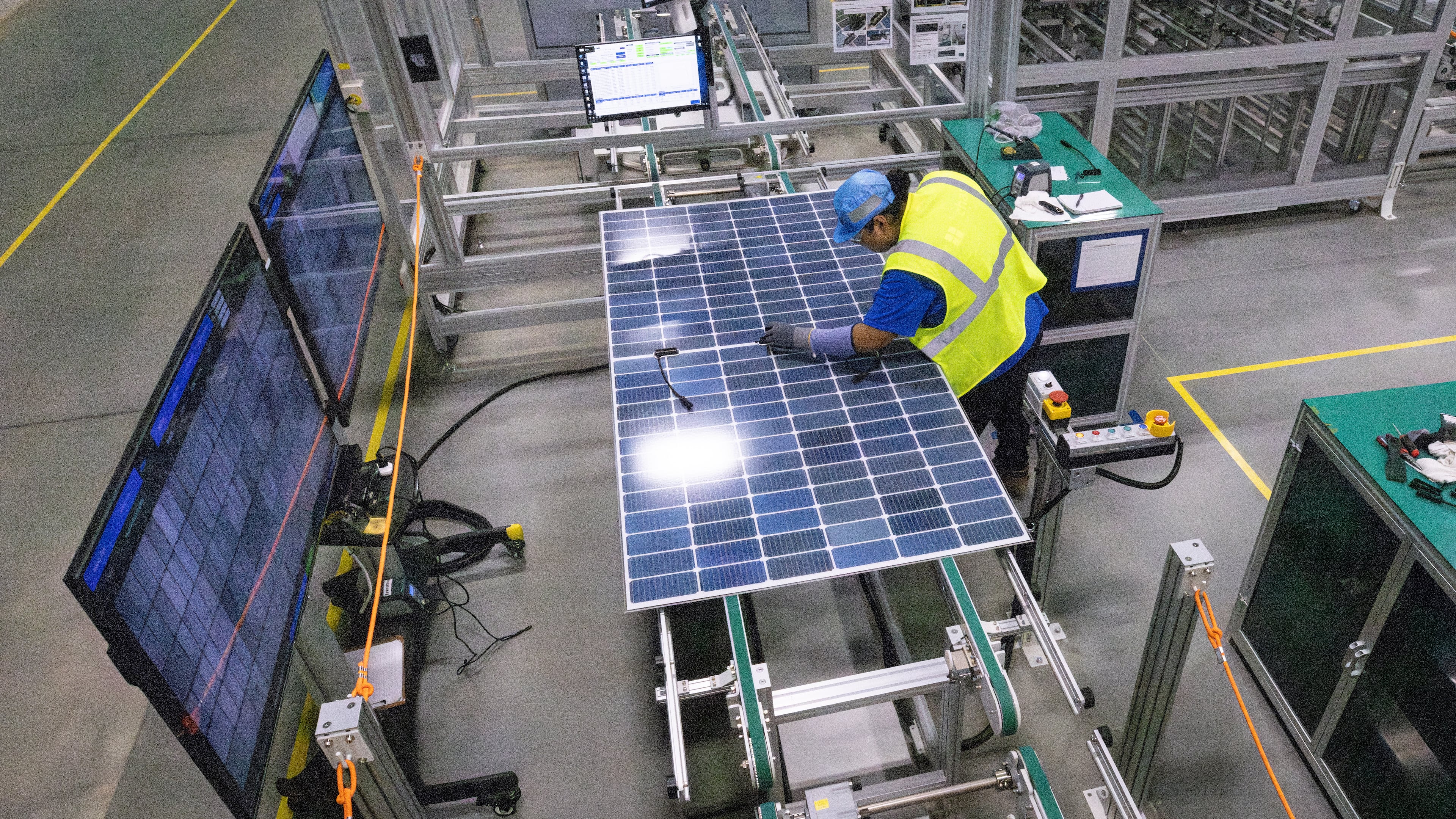 A worker at Qcells' new manufacturing facility in Cartersville conducts quality performance checks on a freshly assembled solar panel on April 2, 2024.