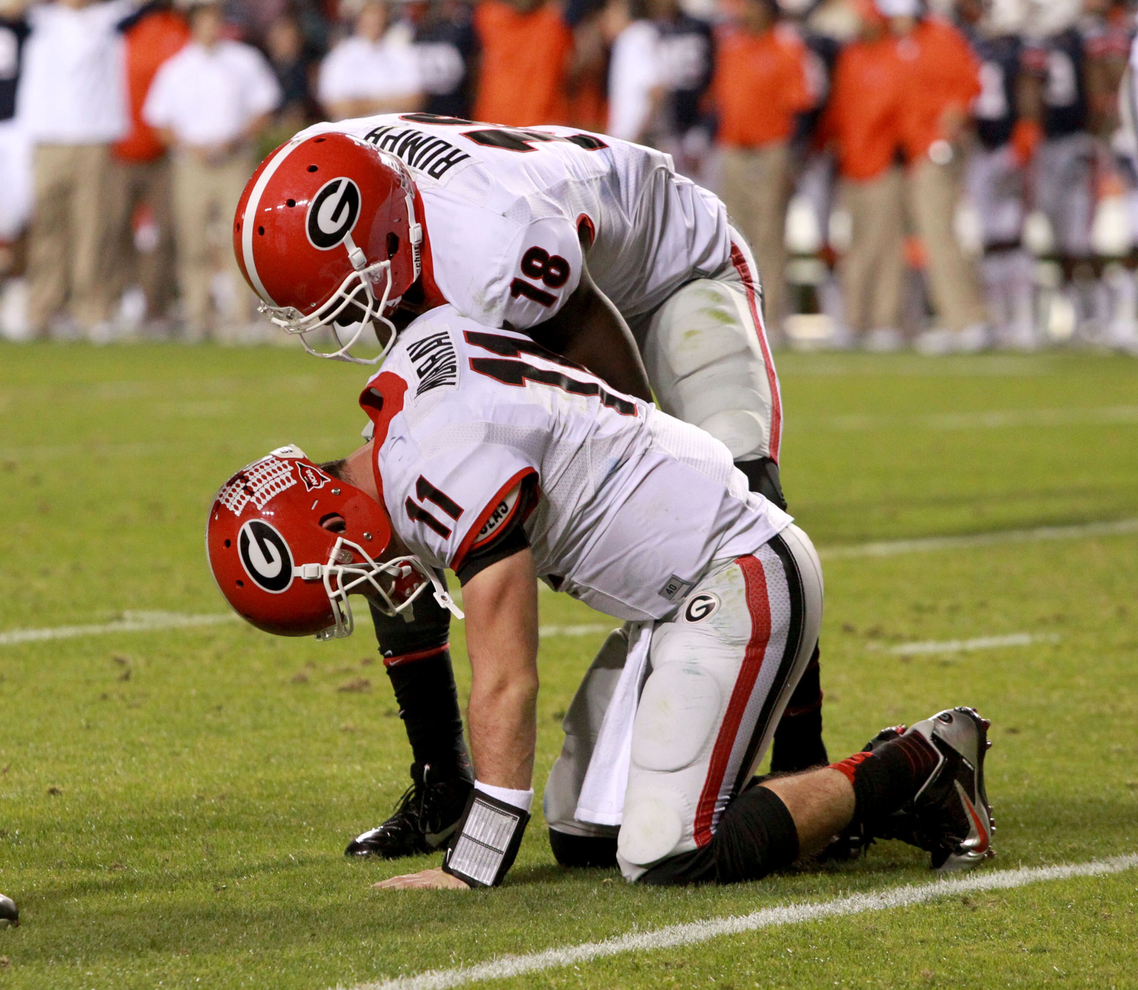 Georgia Bulldogs quarterback Aaron Murray (11) kneels on the ground after getting injured as he scored a 5-yard touchdown run in the fourth quarter to put Georgia ahead as Georgia Bulldogs wide receiver Jonathon Rumph (18) talks to Murray during their game against the Auburn Tigers at Jordan-Hare Stadium Saturday afternoon in Auburn, Al., November 16, 2013. Auburn defeated Georgia 43-38. JASON GETZ / JGETZ@AJC.COM
