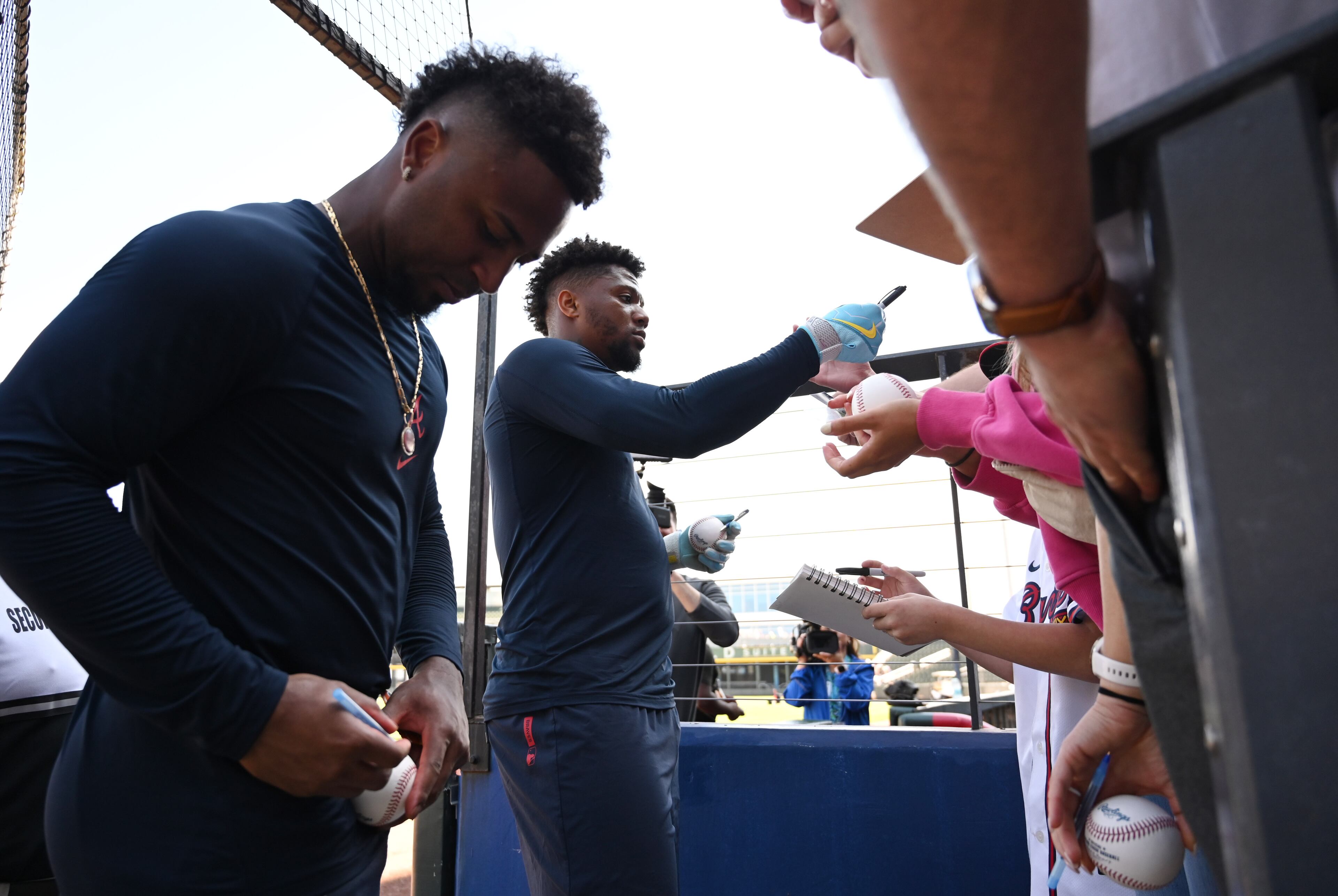 Atlanta Braves second baseman Ozzie Albies (left) and Atlanta Braves right fielder Ronald Acuña Jr. sign an autograph for fans during spring training workouts at CoolToday Park, Saturday, Feb. 14, 2026, in North Port, Fla. (Hyosub Shin/AJC)