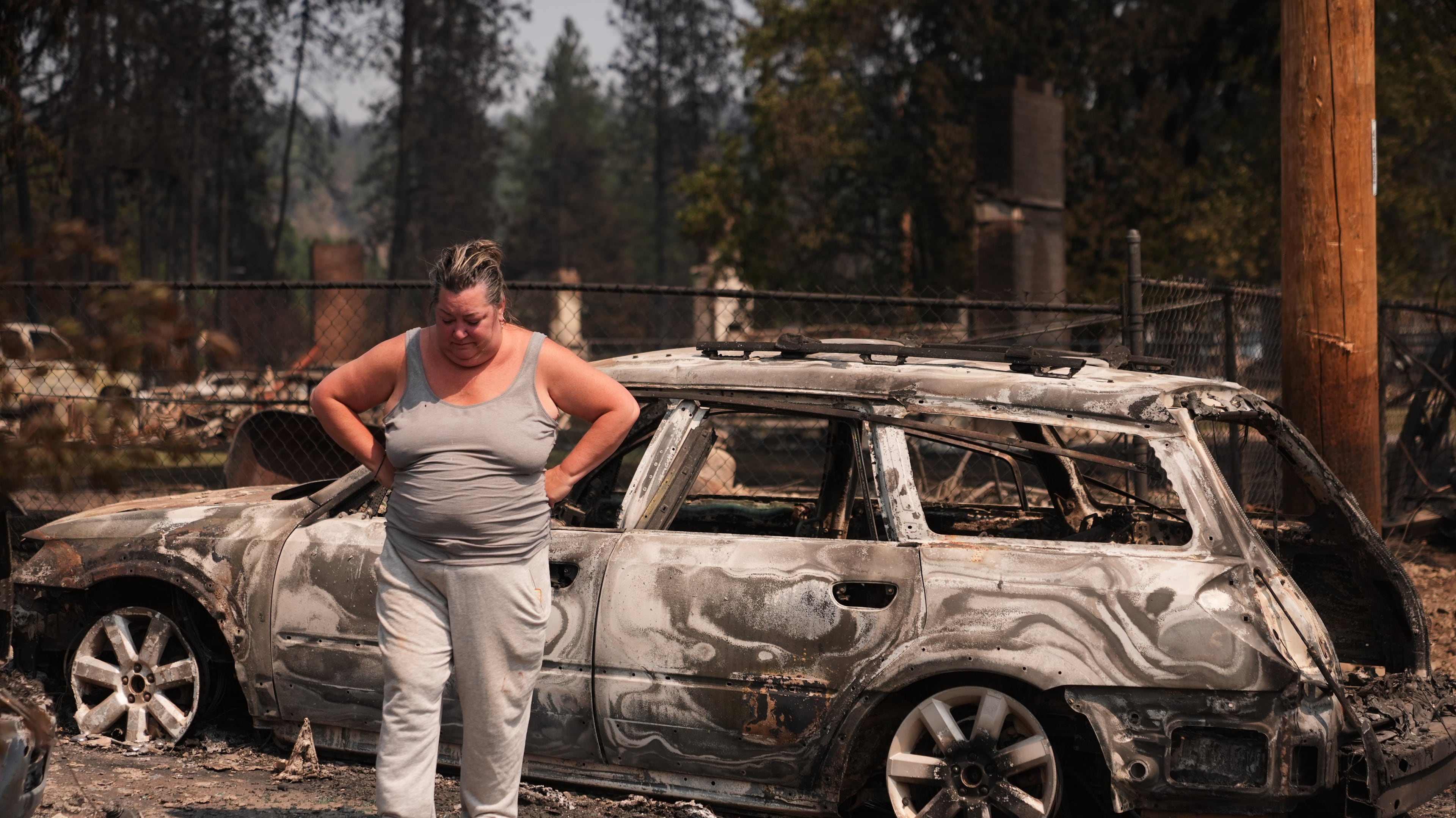 Michelle Angstrom reacts to her burned down home and property after a wildfire hit the northwest part of Spokane, Wash., Tuesday, Aug. 4, 2026. (AP Photo/Lindsey Wasson)