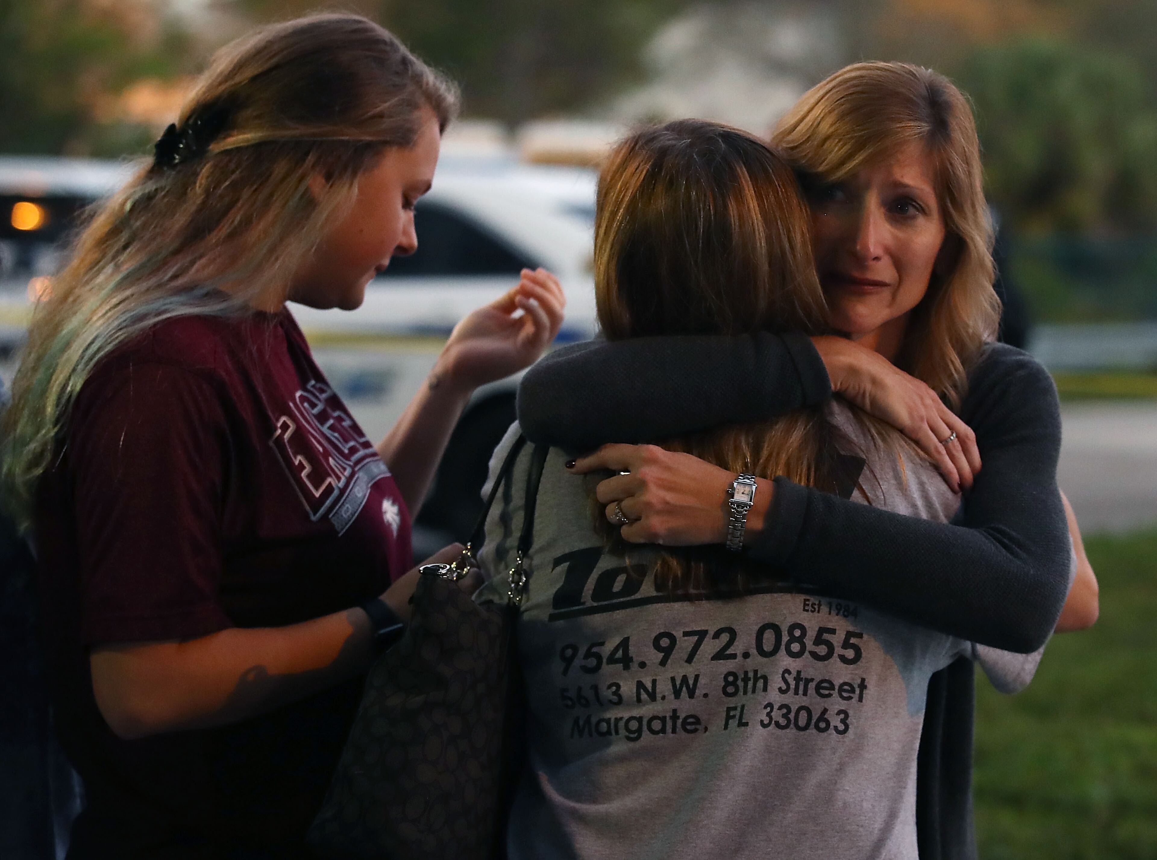 PARKLAND, FL - FEBRUARY 15: Kristi Gilroy (R), hugs a young woman at a police check point near the Marjory Stoneman Douglas High School where 17 people were killed by a gunman yesterday, on February 15, 2018 in Parkland, Florida. Police arrested the suspect after a short manhunt, and have identified him as 19-year-old former student Nikolas Cruz. (Photo by Mark Wilson/Getty Images)