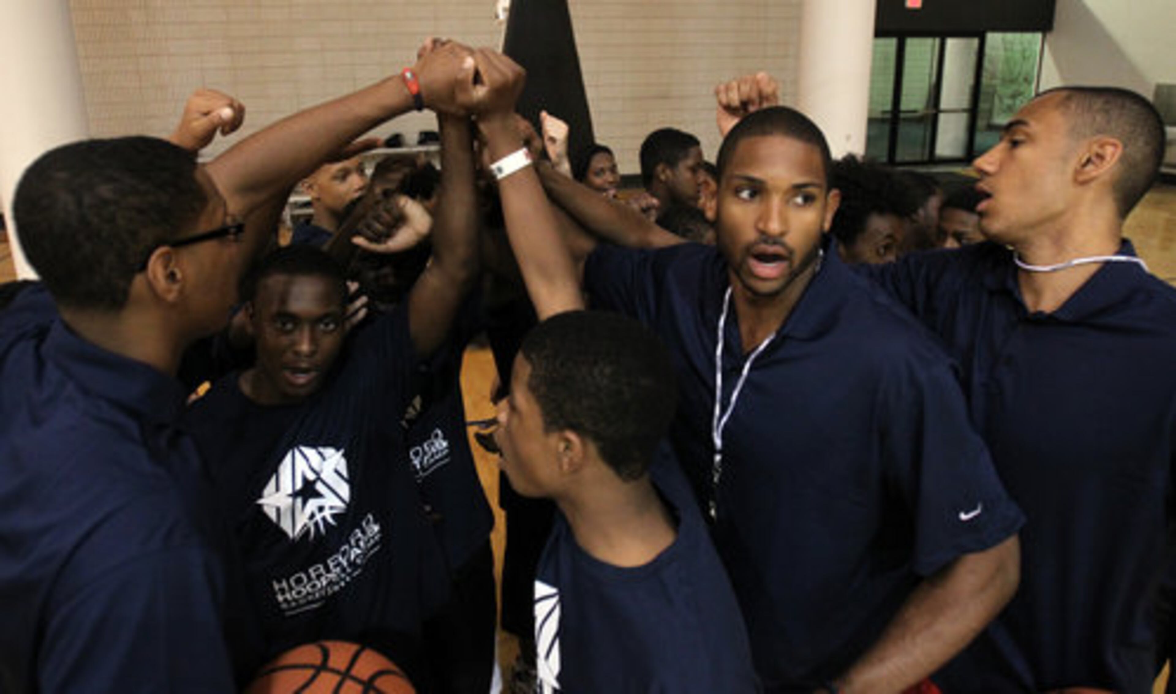 Atlanta Hawks forward Al Horford, second from right, breaks down a huddle with brother Jon Horford, right, and friend and future NBA player Trey Thompkins, left, during the Horford Hoopstars Basketball Camp.
