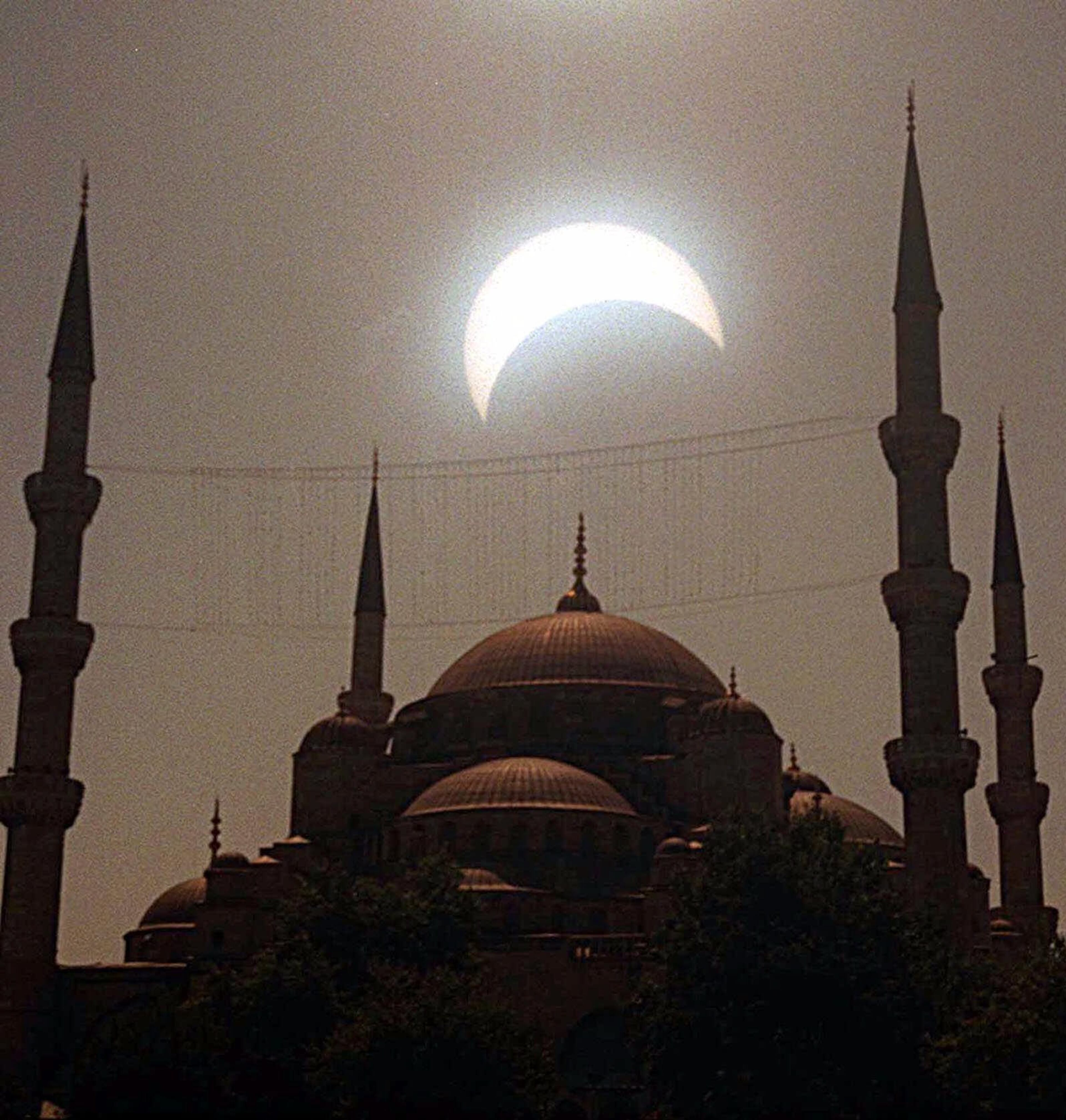 The solar eclipse is seen between the minarets of the historical Blue Mosque in Istanbul, Turkey on Wednesday August 11, 1999. This is the last solar eclipse of this millenium, which swept across Europe towards the Bay of Bengal. (AP Photo/Erhan Sevenler/Anatolia)