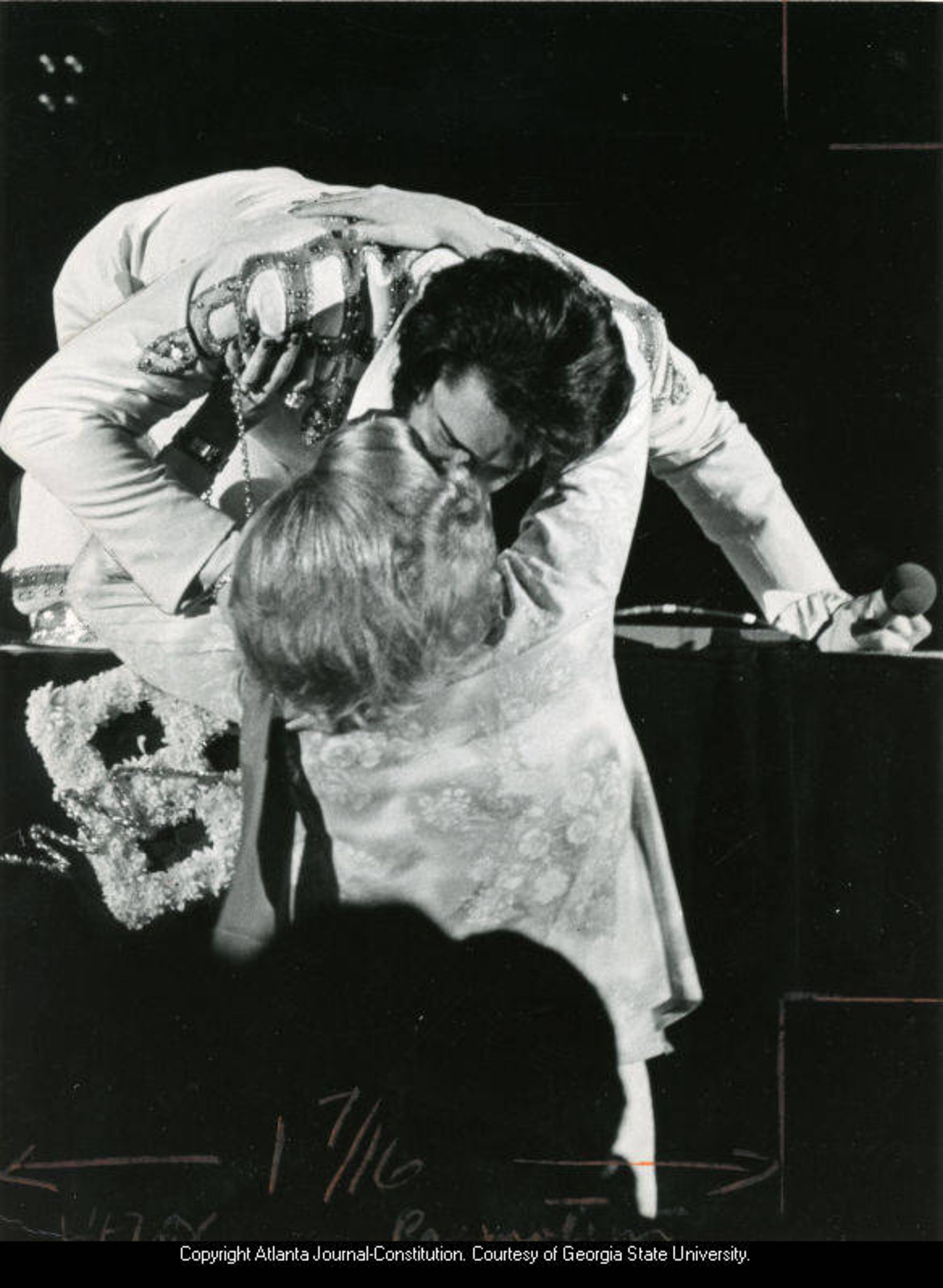 Elvis Presley bends down from the stage to kiss a fan during an Atlanta show on April 30, 1975.