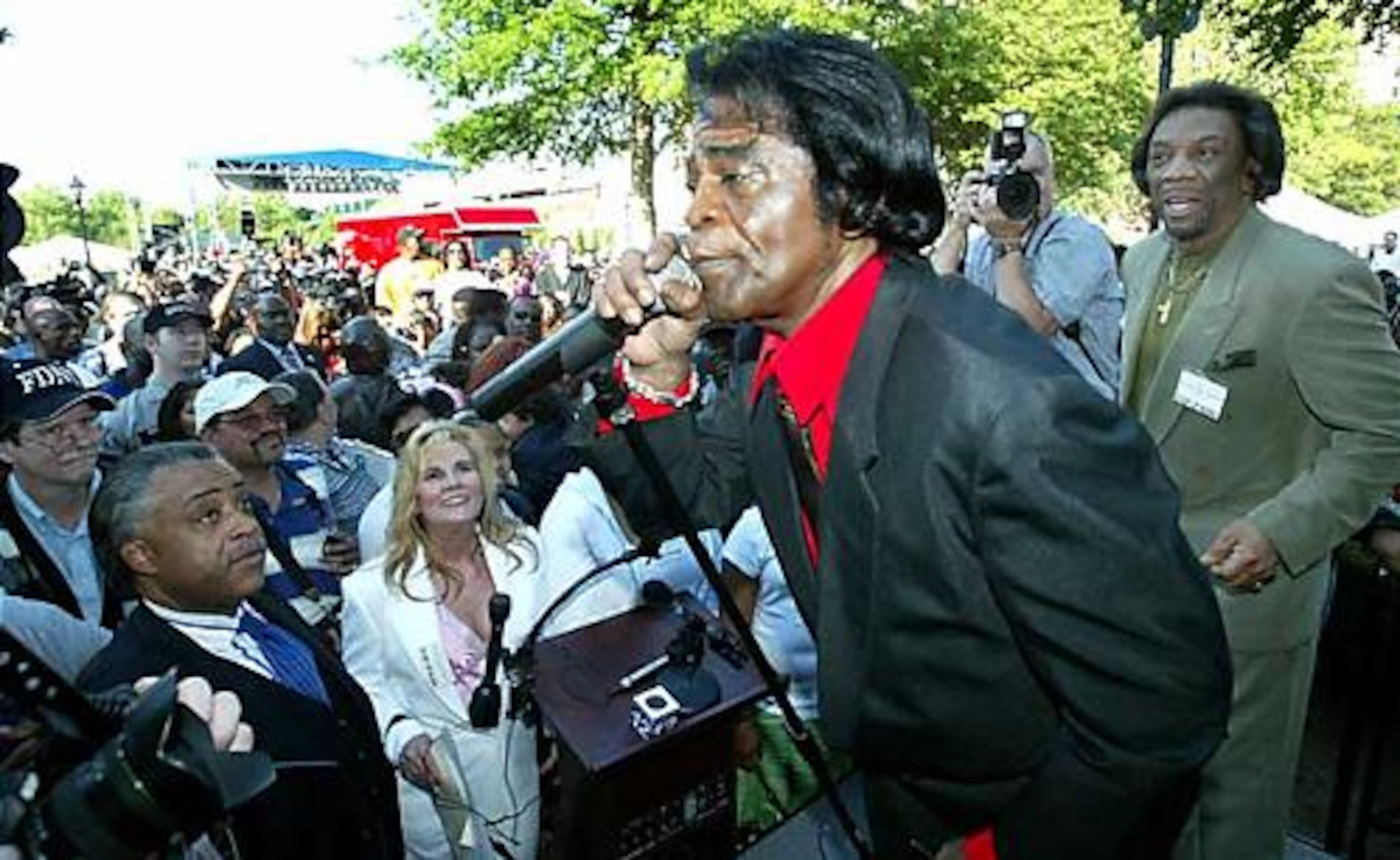 Bobby Byrd stands behind James Brown as he sings a few of his hits on stage at the unveiling of his statue in Augusta in May of 2005.