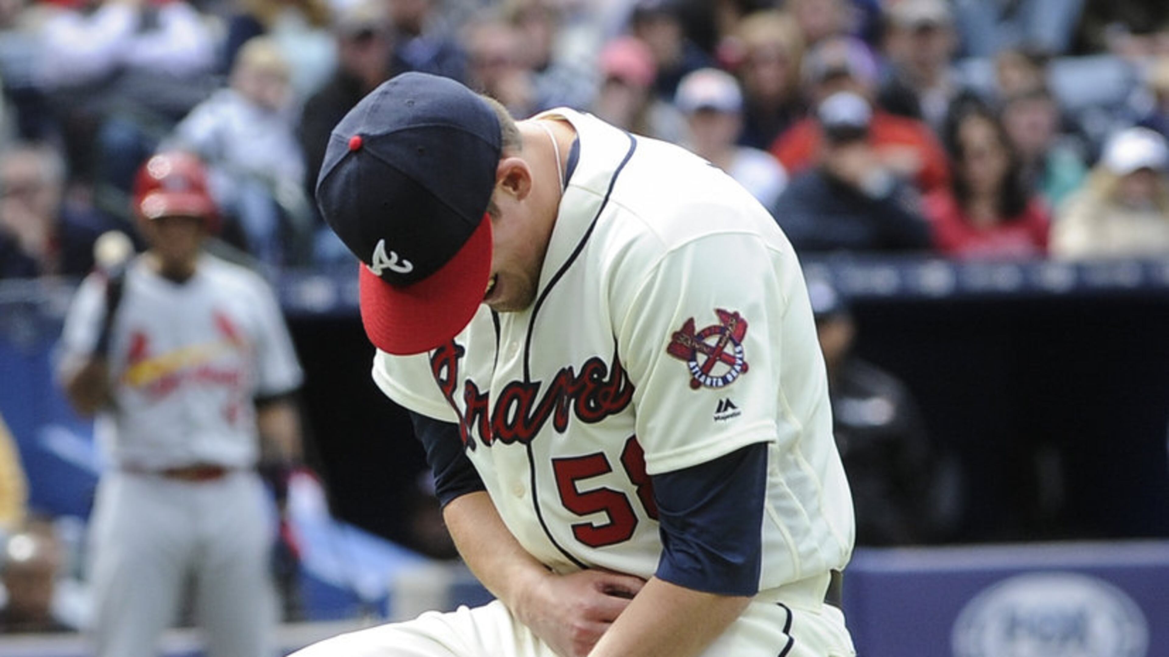 Braves reliever Dan Winkler collapses after fracturing his right elbow throwing a pitch in a game on April 10, 2016. (AP Photo/John Amis)