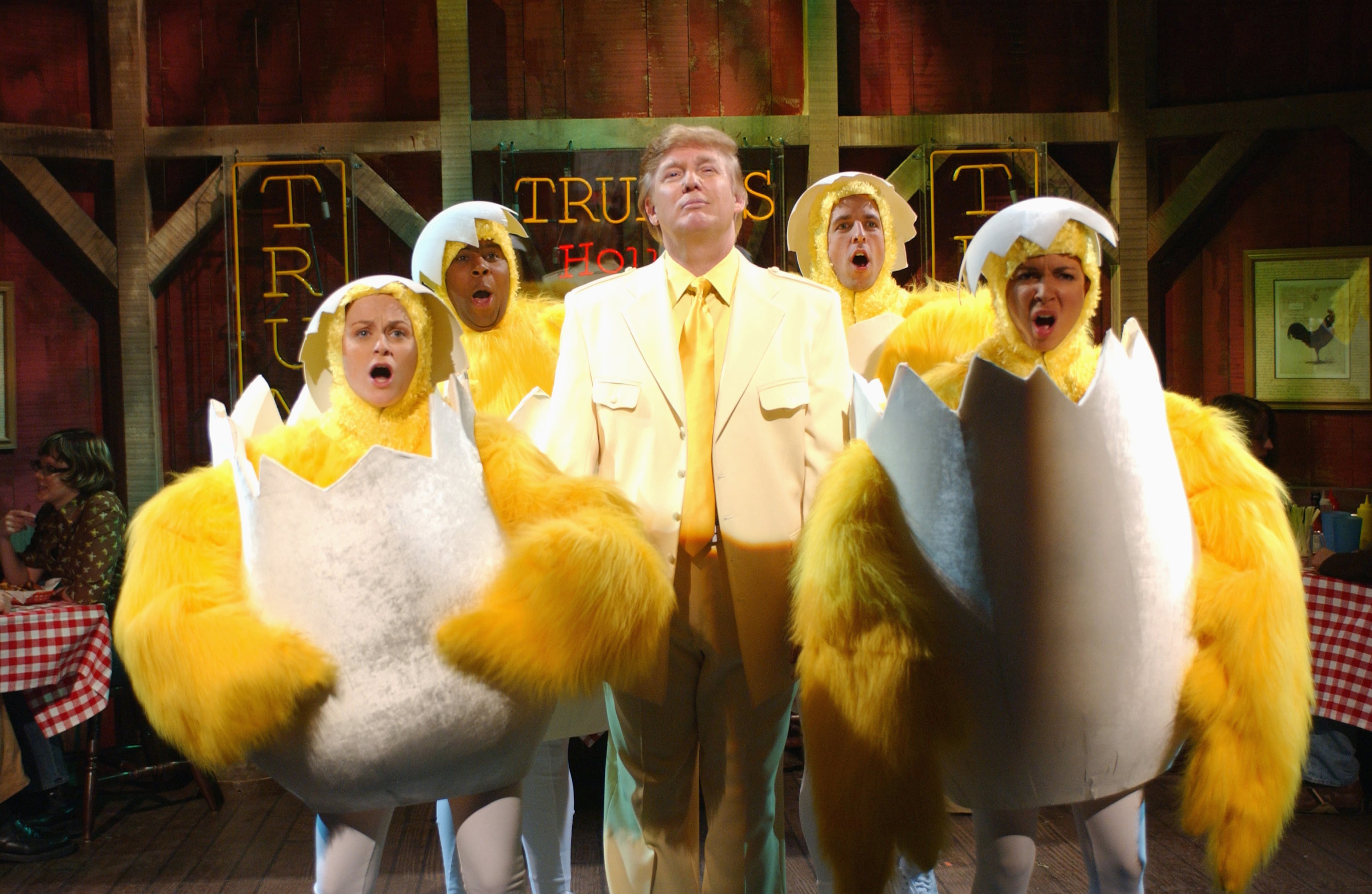 SATURDAY NIGHT LIVE -- Episode 16 -- Air Date 04/03/2004 -- Pictured: (l-r) Amy Poehler, Kenan Thompson, Donald Trump, Seth Meyers, Maya Rudolph during the "Donald Trump's House of Wings" skit on April 3, 2004 (Photo by Mary Ellen Matthews/NBC/NBCU Photo Bank via Getty Images)