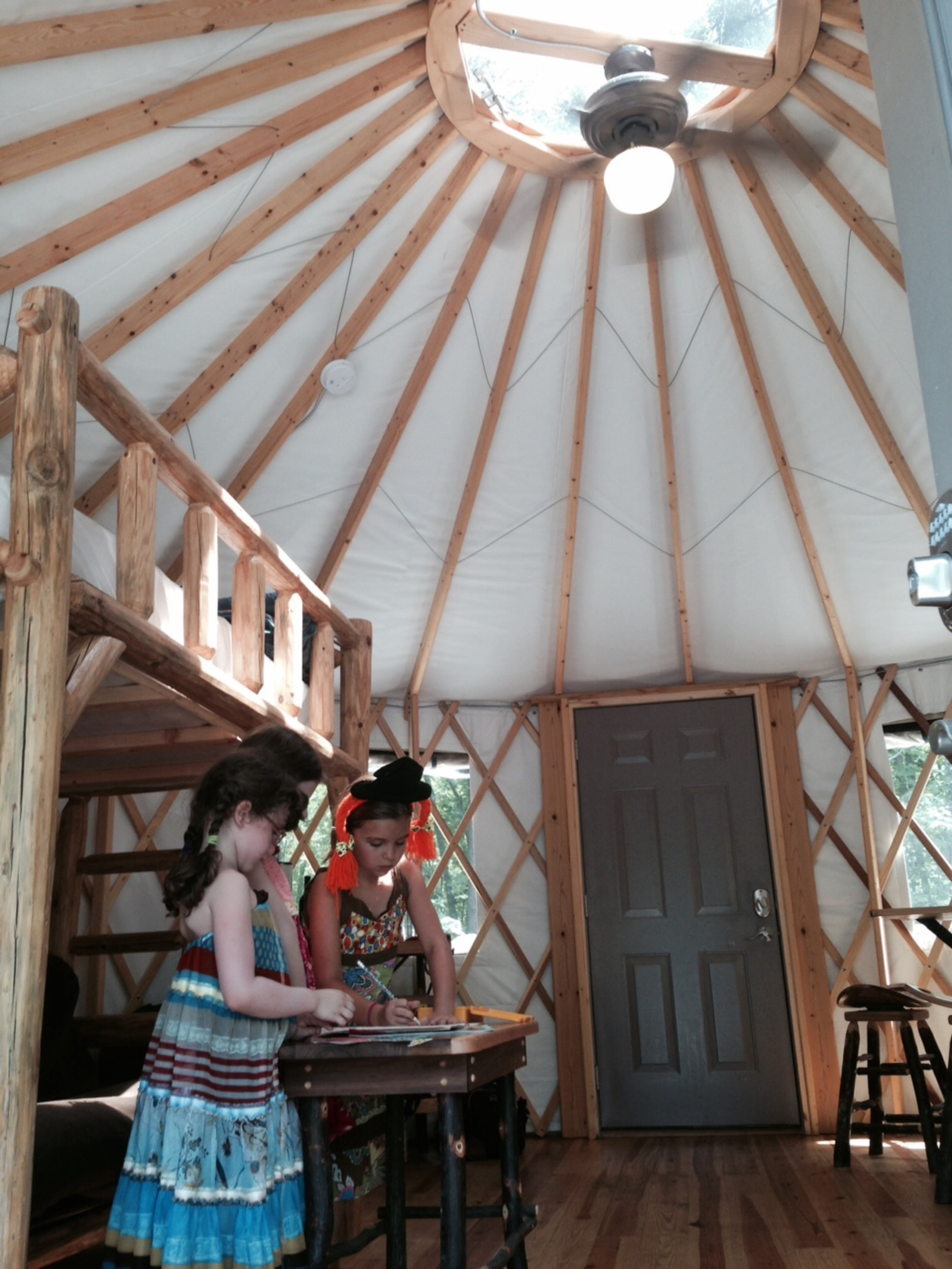Tali, Mira and Isabel prepare for a performance inside the yurt.