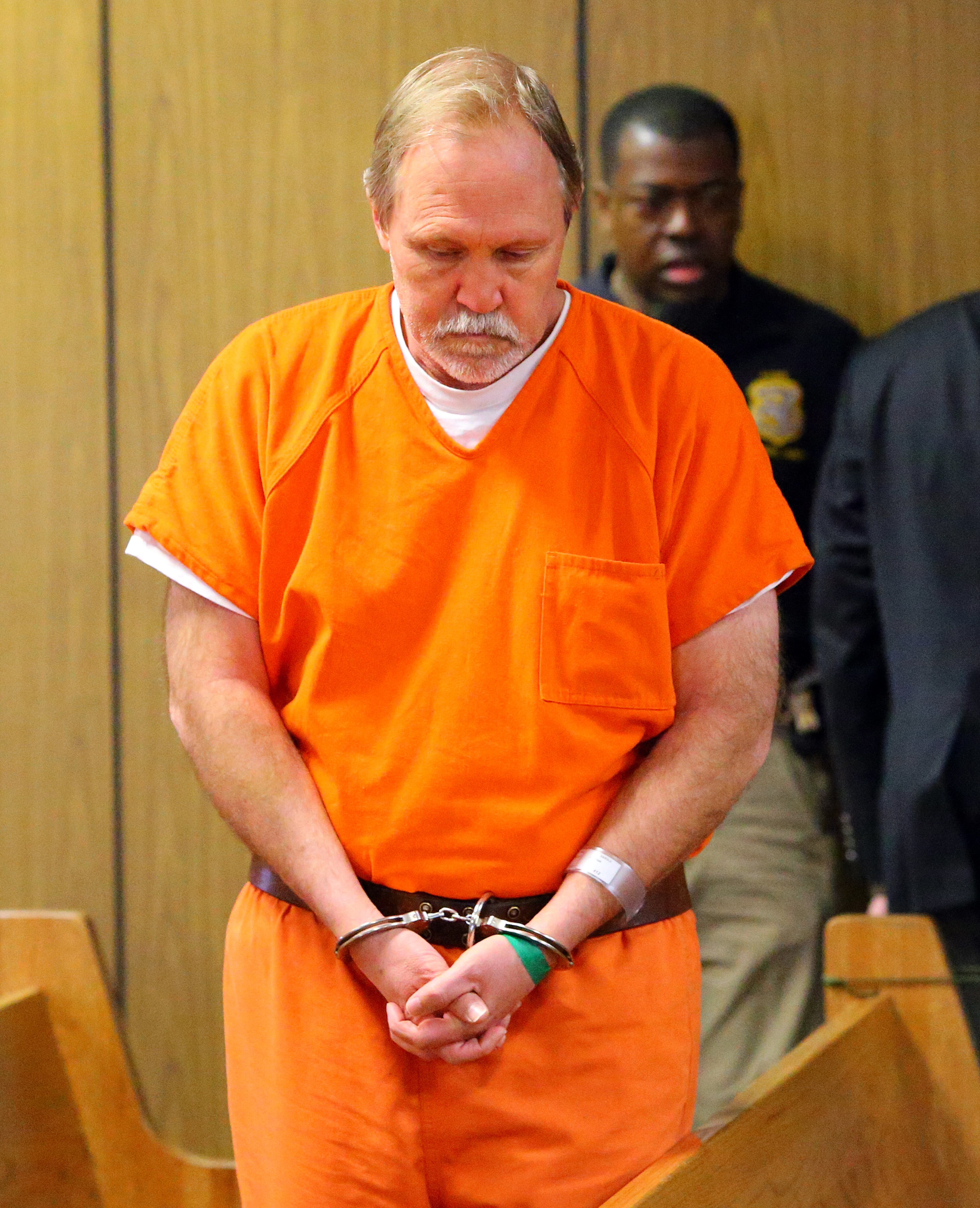 John McGill, principal of Mt. Carmel Elementary School in Douglas County, is escorted into the courtroom for his first appearance hearing at DeKalb County Magistrate Court for a felony offense of electronic pornography and attempting to have sex with a minor on Tuesday, March 4, 2014, in Decatur.
