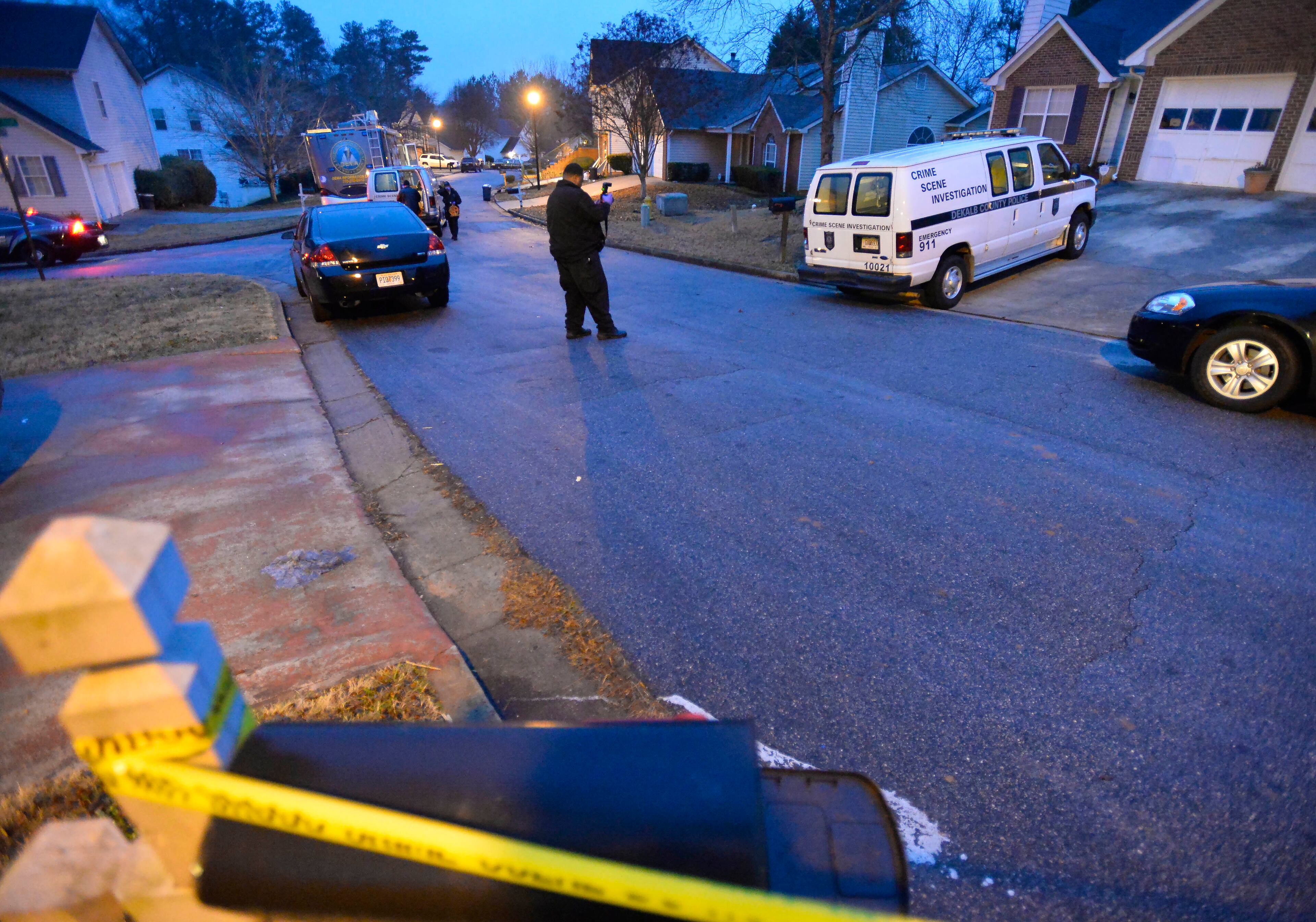 DeKalb police officials investigate the scene on Landgraf Cove, in a neighborhood off River Road, where a gunman fired shots at SWAT team officers during a five-hour standoff early Monday morning, Dec. 22, 2014, in the southern part of the county. When officers entered the house, the gunman was found dead. DAVID TULIS / AJC SPECIAL